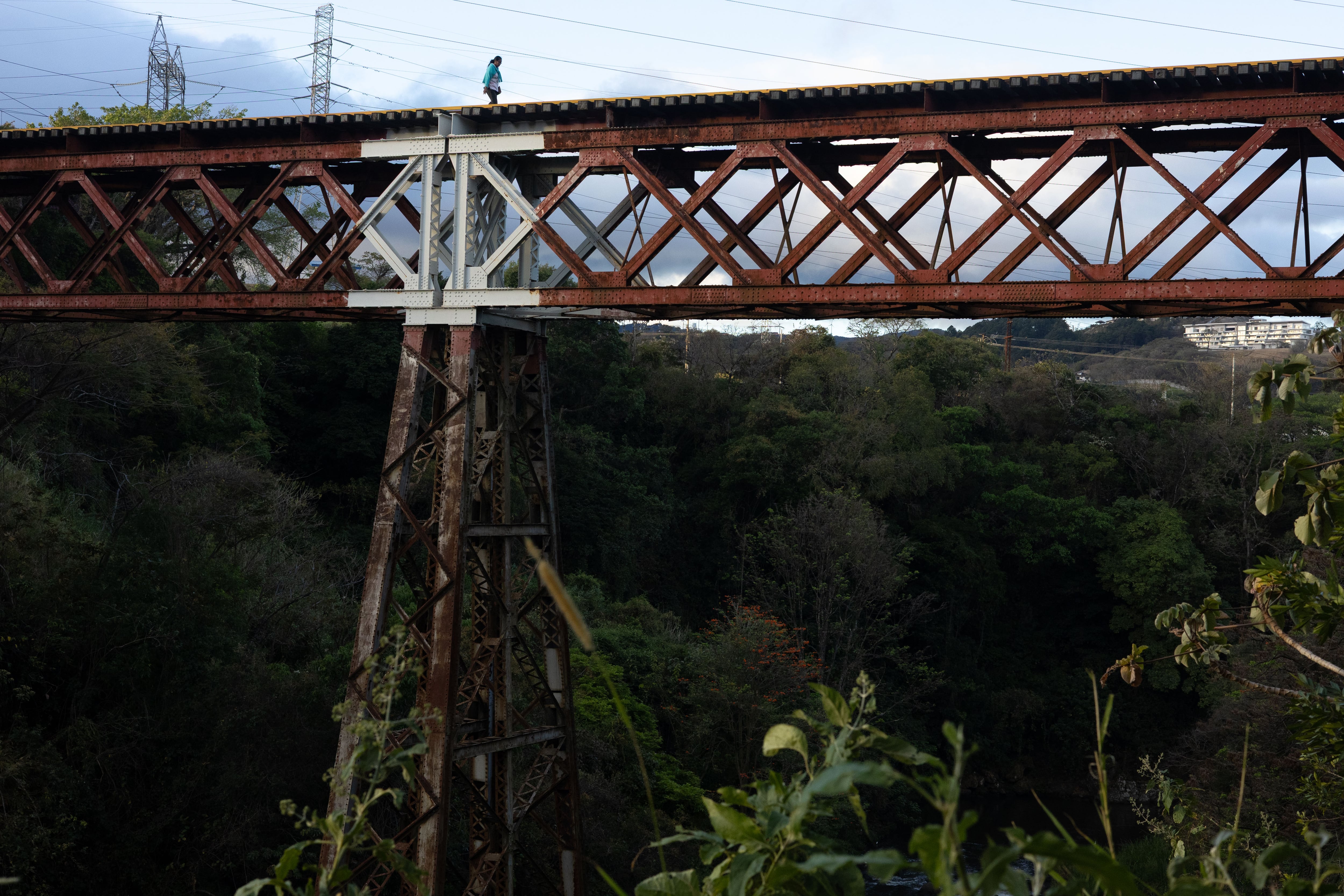 Una señora cruza el puente que une Lomas, La Carpio y Cariari.