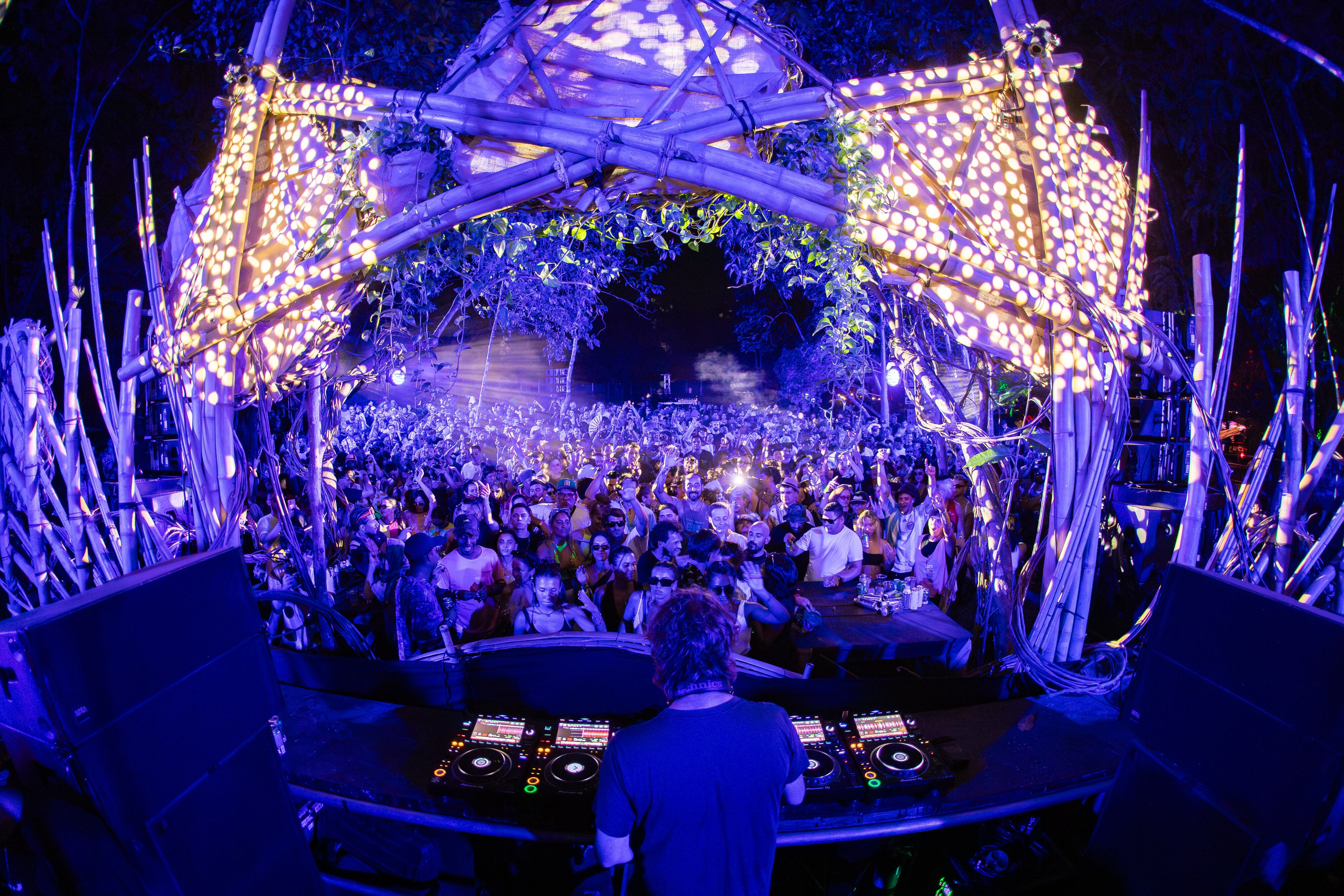 Imagen de un DJ de música electrónica mezclando frente a una gran audiencia.