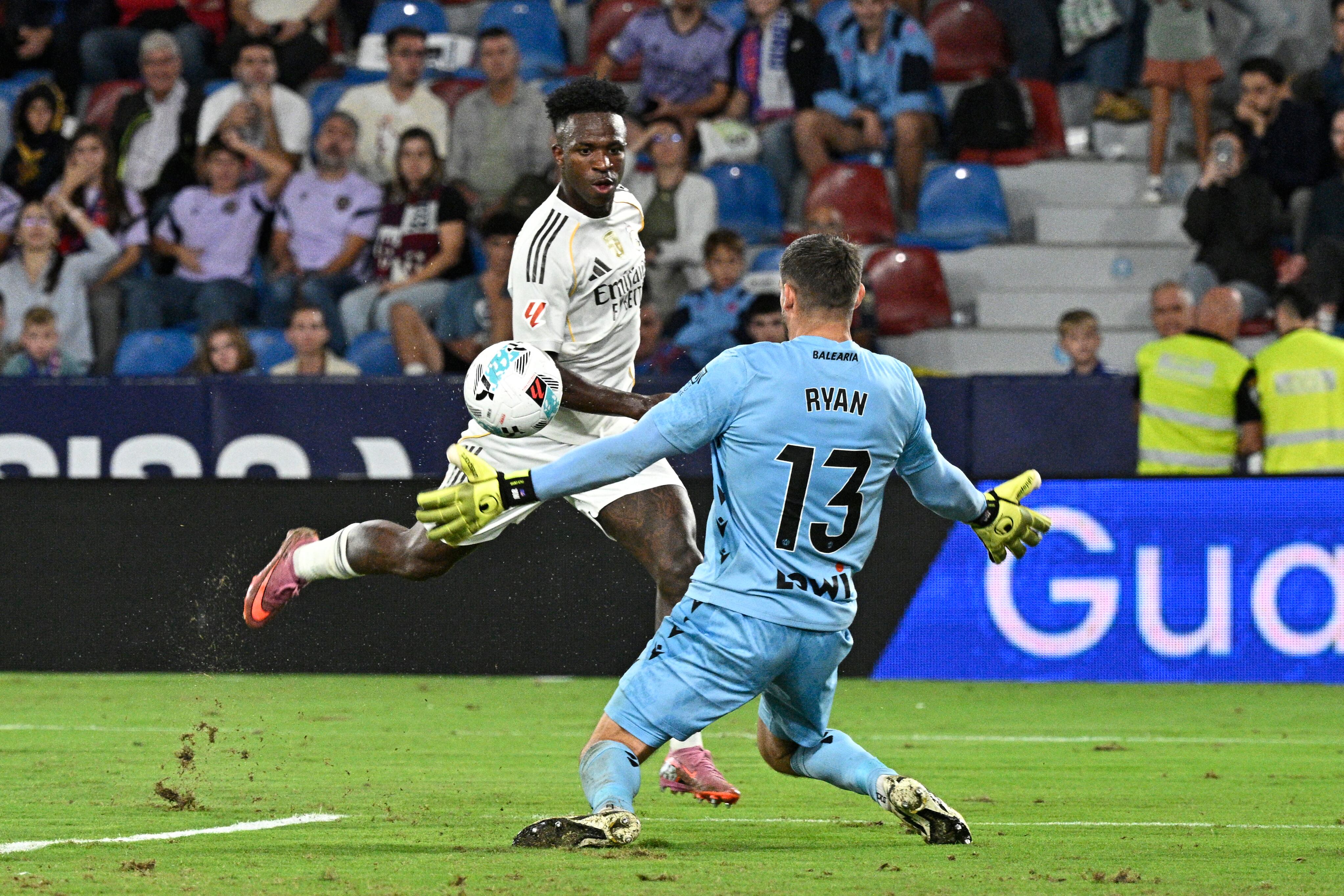 El delantero del Real Madrid Vinícius saca un remate ante el arquero del Levante Mathew Ryan, durante el compromiso por la Liga Española.