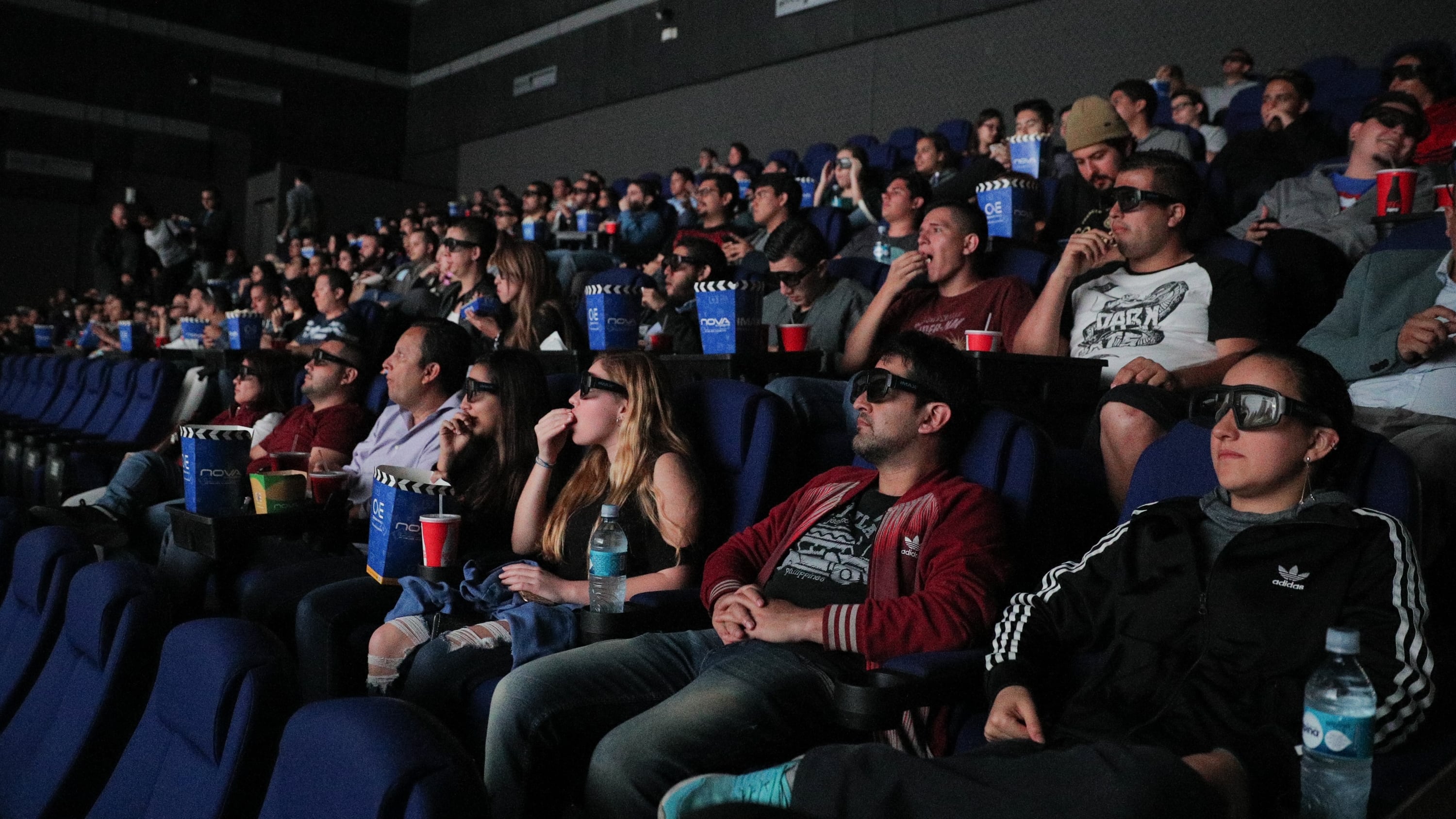 Público en una sala de cine, comiendo palomitas y con lentes de 3D