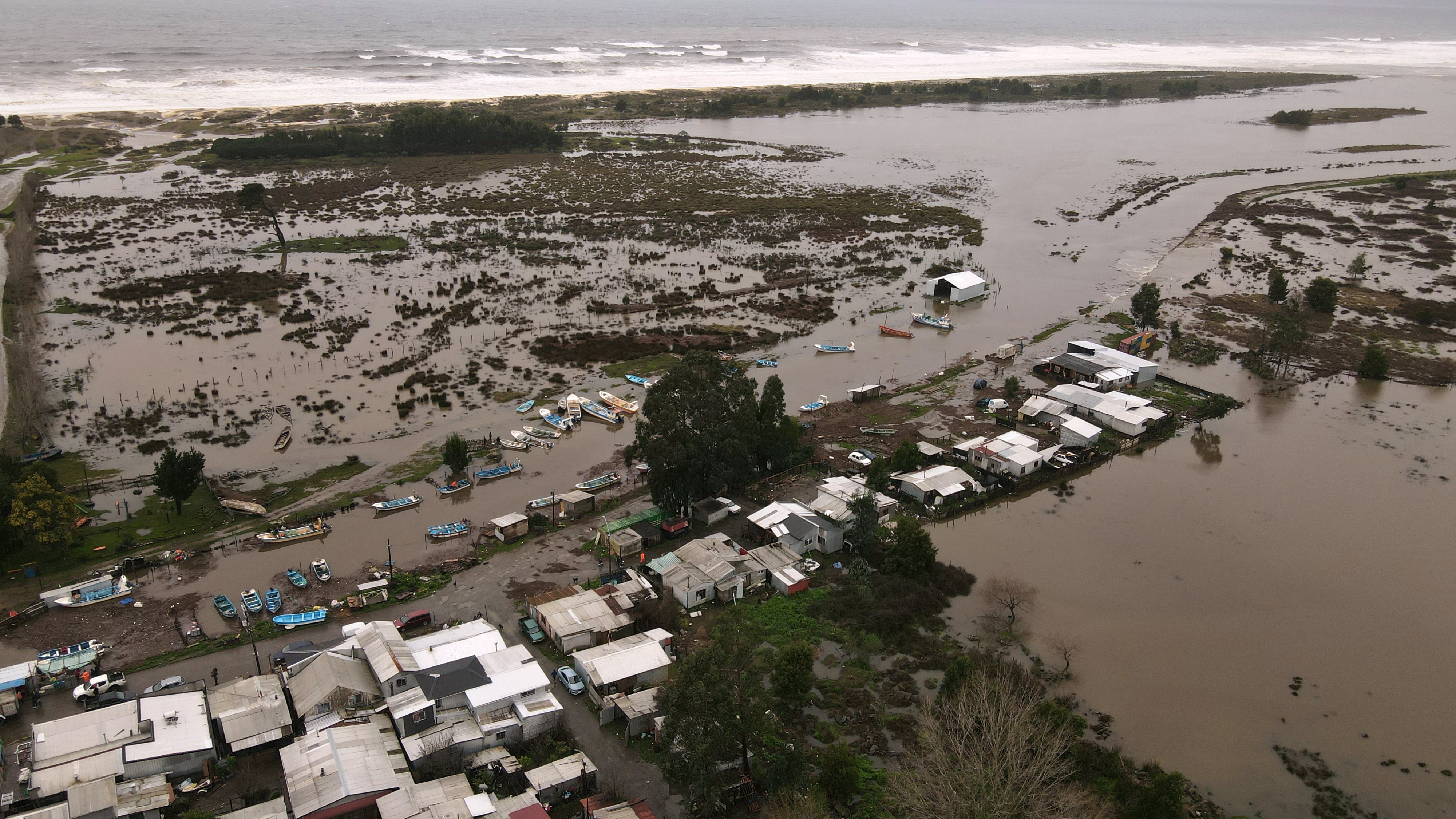 This aerial view shows a flooded area in the coastal city of Arauco, BioBio region, province of Arauco, Chile on July 16, 2026, following strong storms hitting the region. Three people died and 76 were affected amid a storm with heavy rains, swells, and winds that is impacting 10 of the country�s 16 regions, the government reported. (Photo by GUILLERMO SALGADO / AFP)