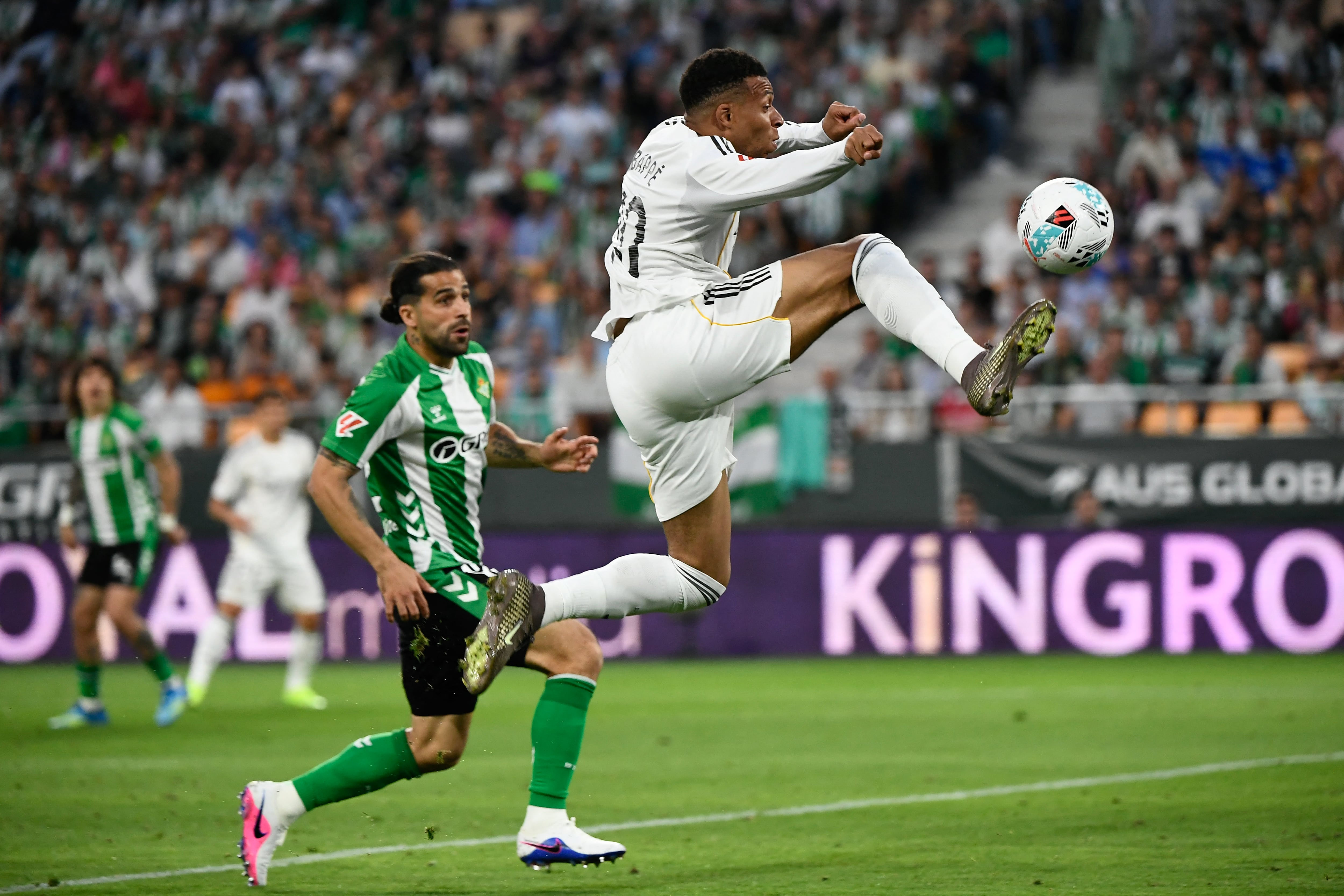 El delantero francés del Real Madrid Kylian Mbappé controla el balón ante la marca del suizo Ricardo Rodriguez, del Betis, durante el compromiso por la Liga Española.