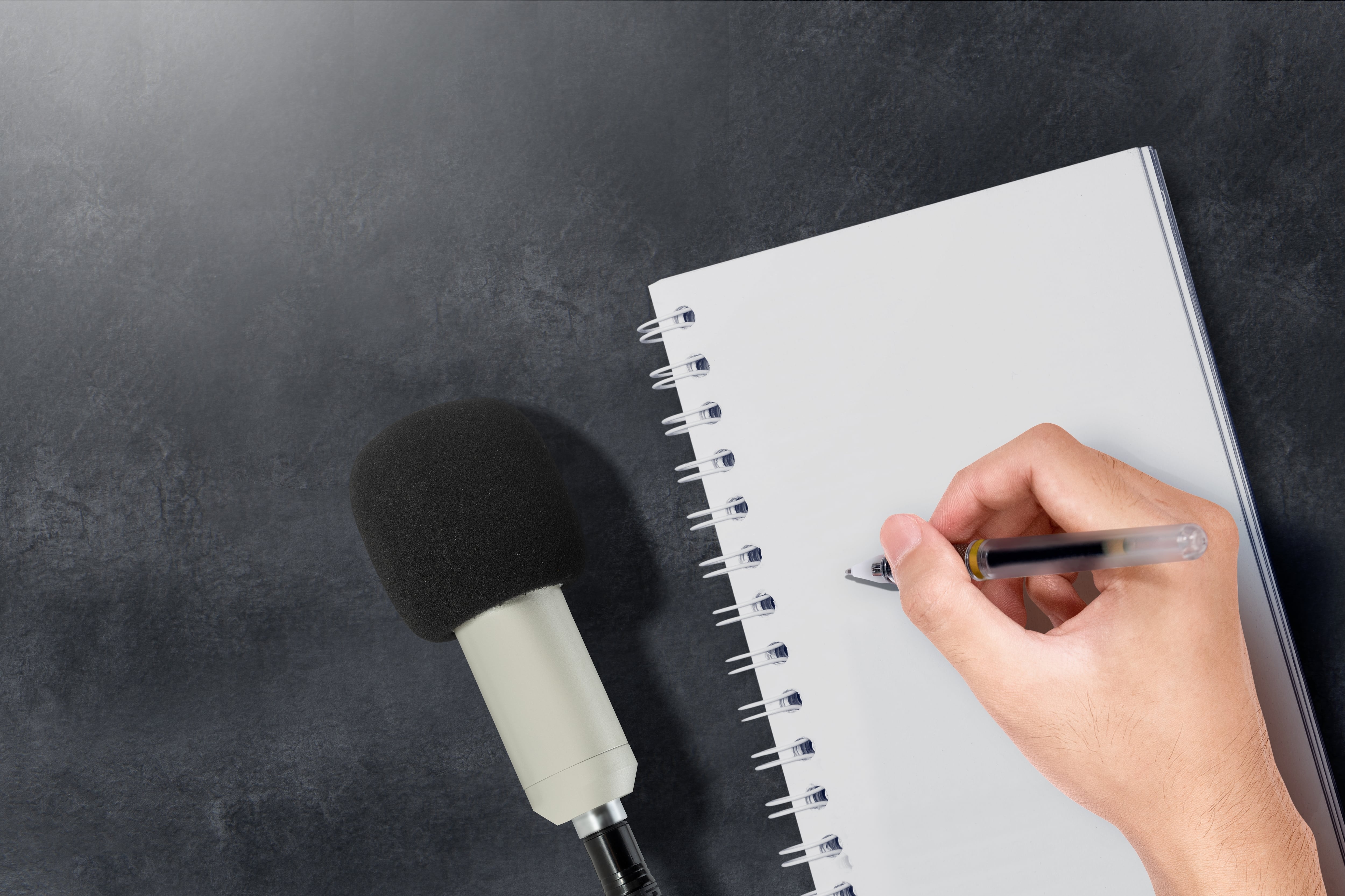 prensa, periodismo, micrófono, libreta de periodista, mano empuña bolígrafo y toma nota en libreta