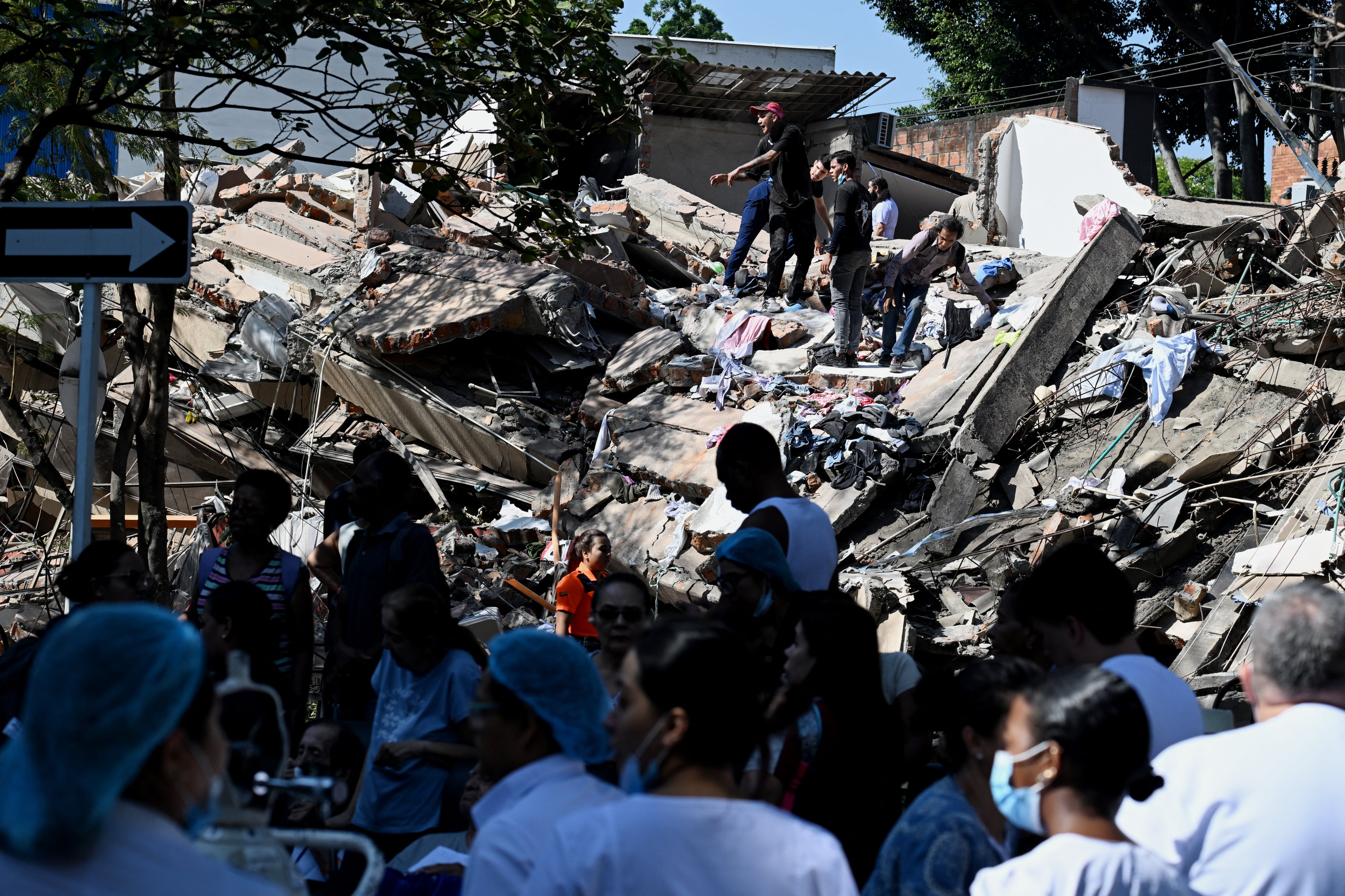 Personas trabajan en un edificio colapsado tras un terremoto en Cali.