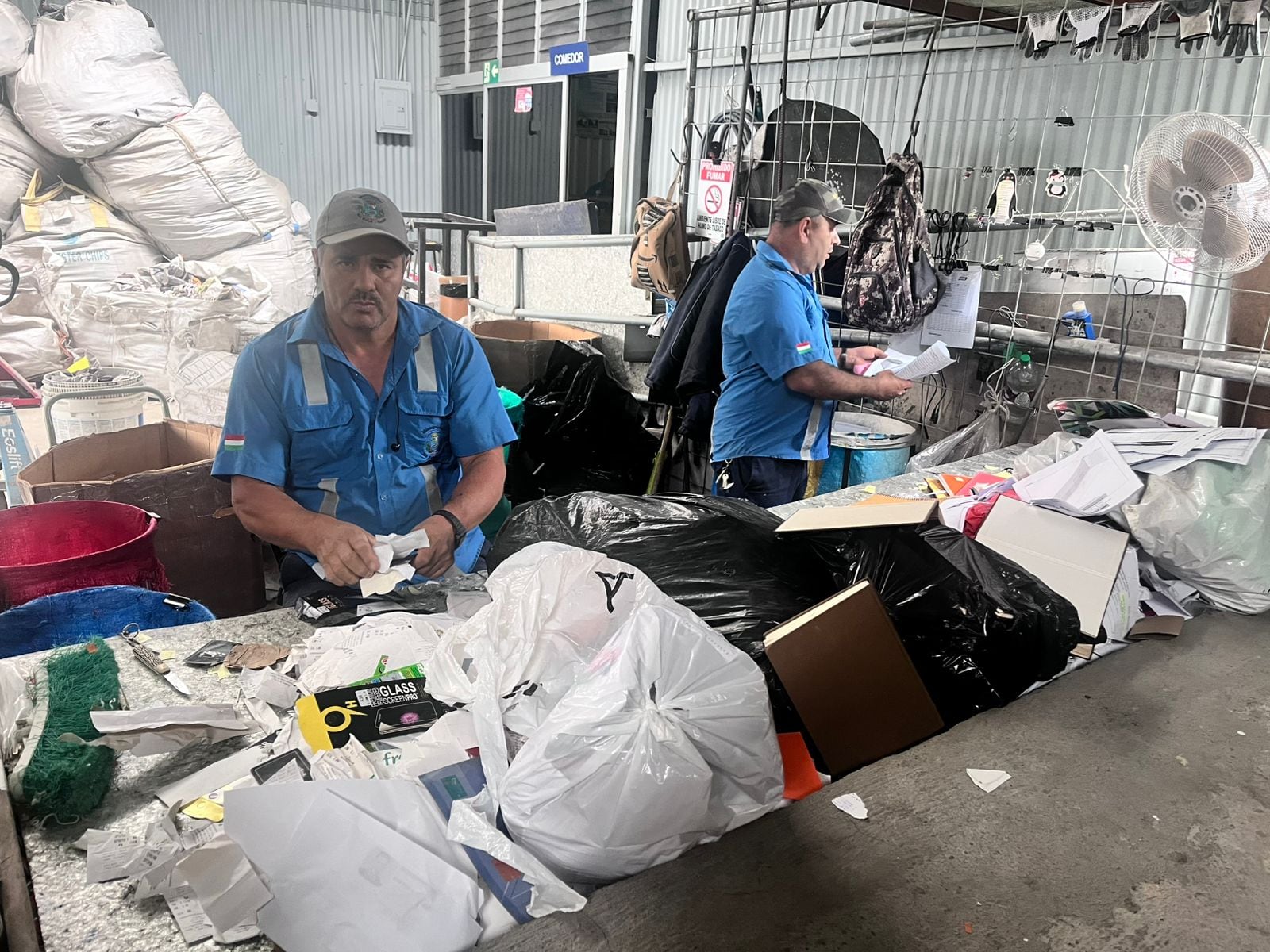 Dos trabajadores de un centro de acopio manipulan los desechos.