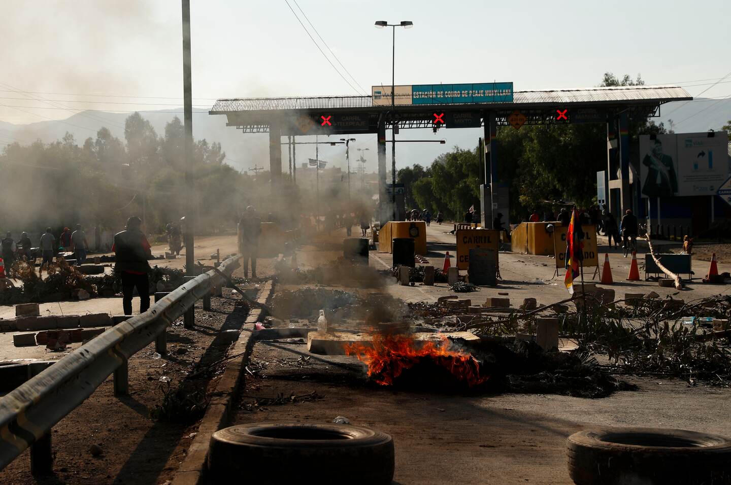 Tires burn at a toll station in Sacaba, Bolivia, Saturday, Nov. 16, 2019. Bolivia’s political crisis turned deadly after security forces opened fire on supporters of former President Evo Morales in Sacaba Friday, killing at least five people, injuring dozens and threatening the interim government’s efforts to restore stability following the resignation of the former president in an election dispute. (AP Photo/Juan Karita)