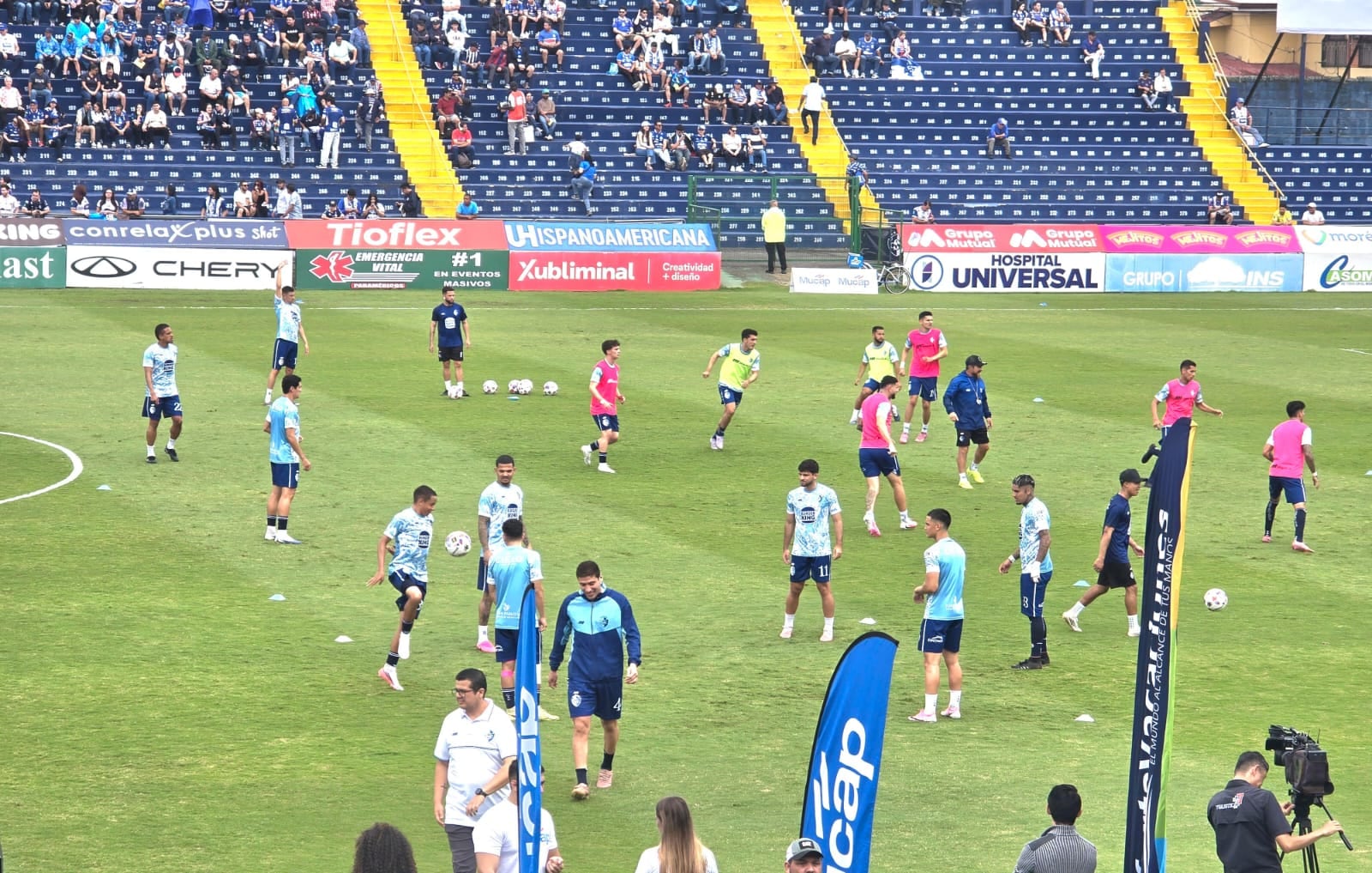 Los jugadores de Cartaginés y Herediano calientan en la gramilla del Fello Meza mientras el ambiente va calentando en las graderías.