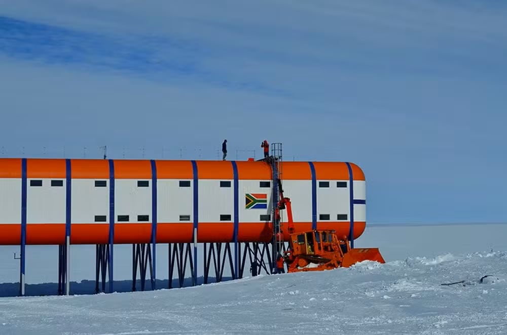 La base Sanae IV, ubicada en la Costa de la Reina Maud, en la Antártida, es una estación de investigación sudafricana diseñada para resistir condiciones extremas. Construida sobre pilares elevados para evitar el soterramiento por la nieve, enfrenta temperaturas de hasta -23 °C y un aislamiento total del exterior.
