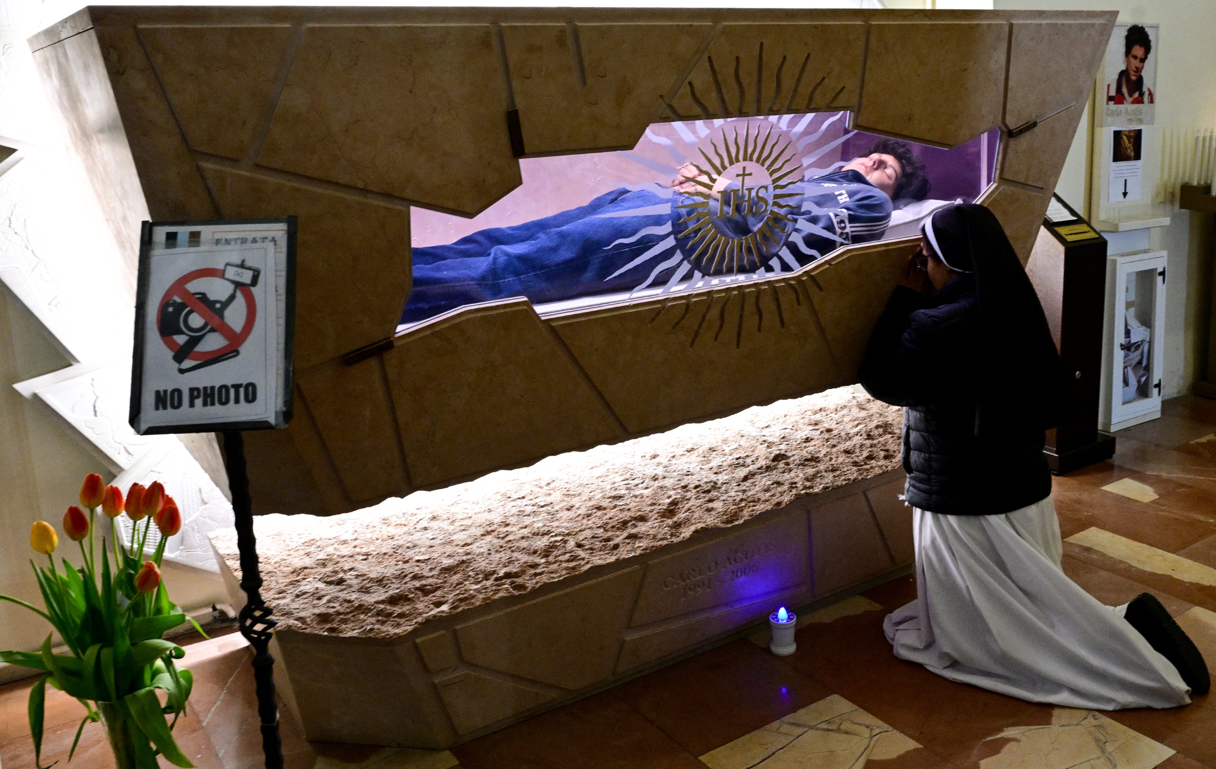 Una monja ante la tumba del beato Carlo Acutis quien dedicó su vida a difundir su fe en línea, ganándose el apodo de "Influencer de Dios", en el Santuario de la Renuncia en Asís, parte de la Iglesia de Santa María la Mayor, en abril de 2025. Fotografía: