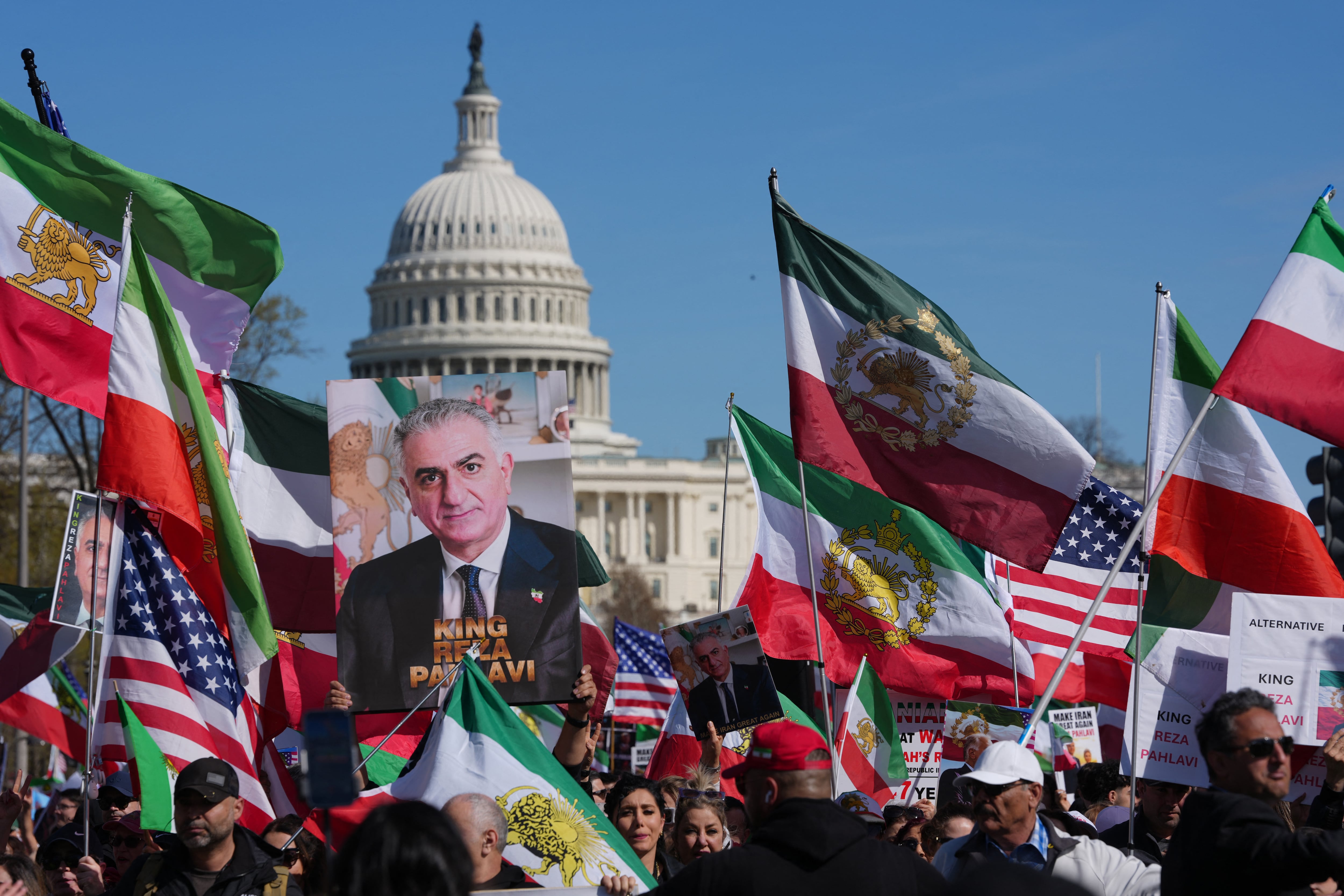 Manifestantes ondean banderas iraníes de la época de la Revolución Islámica de 1979 y portan imágenes de Reza Pahlavi, hijo del último sha de Irán, mientras marchaban cerca del Capitolio de los Estados Unidos durante una concentración en apoyo a la lucha de los iraníes por la libertad, en Washington, D.C., este 29 de marzo.