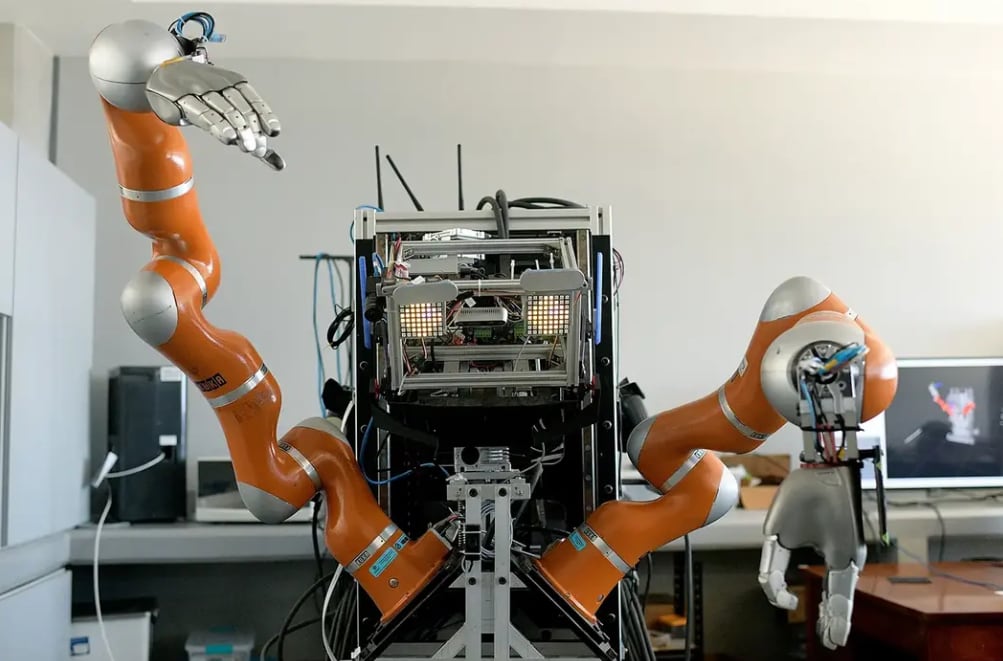 En la imagen se aprecia al robot humanoie del ARCOS-Lab, el cual es capaz de saludar a las personas, interactuar con ellas, tiene una programación que le permite expresar emociones a través de sus ojos.