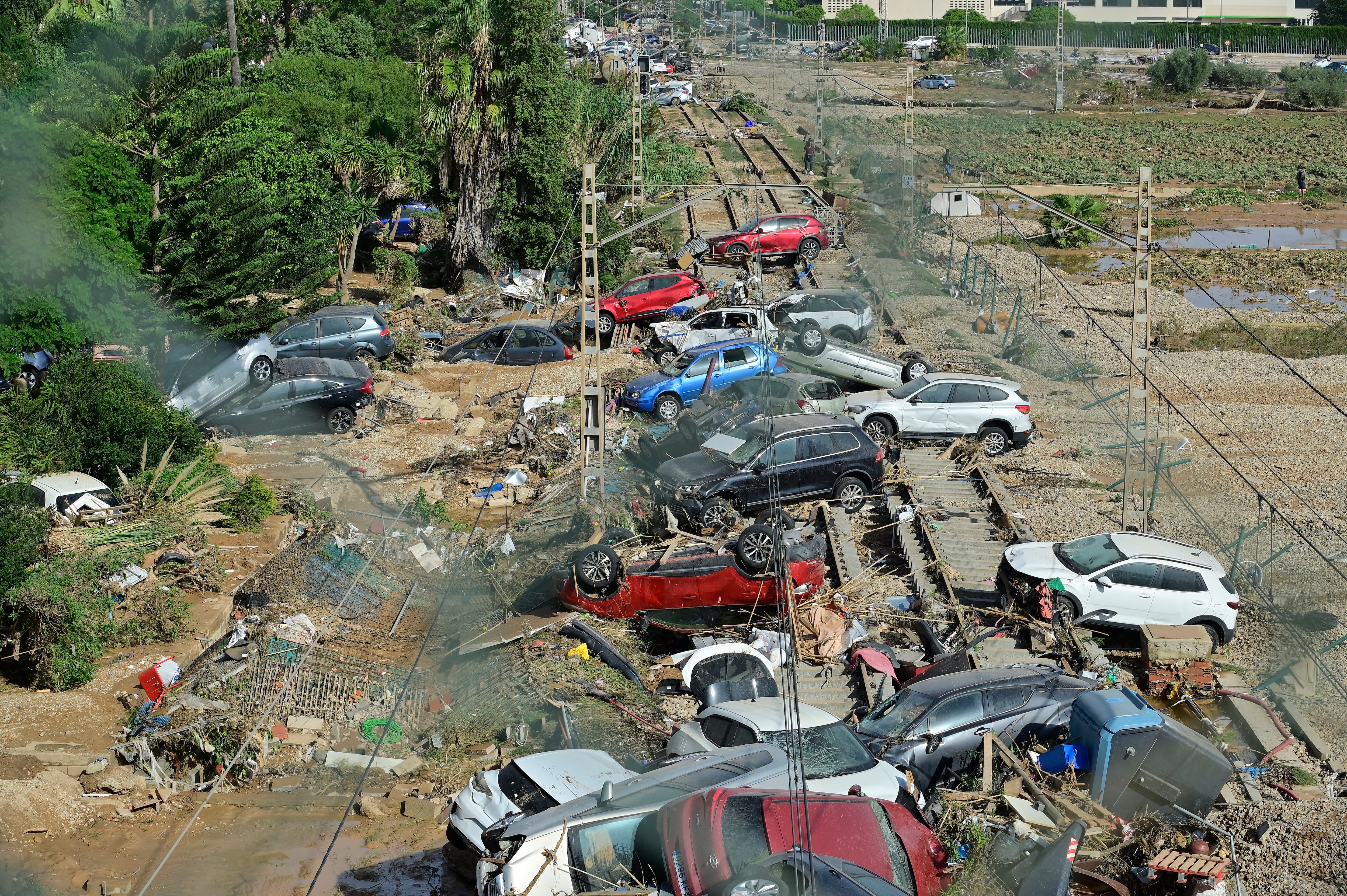 Los restos de los coches se amontonan en la vía del tren después de que las inundaciones repentinas asolaran la ciudad de Alfafar, en la región de Valencia, en el este de España. Los equipos de rescate se apresuraron para encontrar supervivientes y víctimas de las inundaciones.