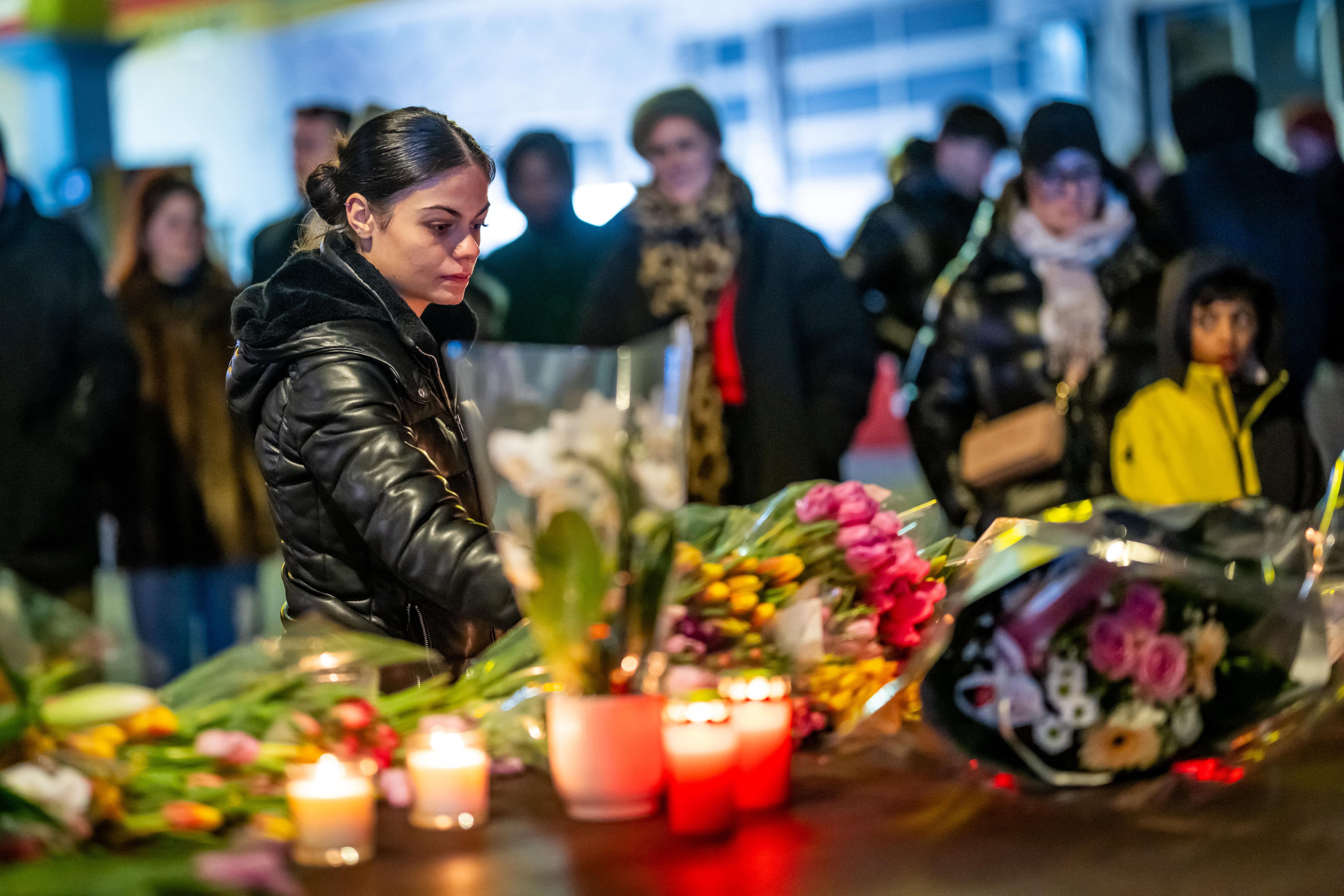 Una mujer deposita flores cerca del lugar donde un incendio arrasó un bar abarrotado durante las celebraciones de Nochevieja en la estación de esquí alpina de Crans-Montana, este 1 de enero. Fotografía: