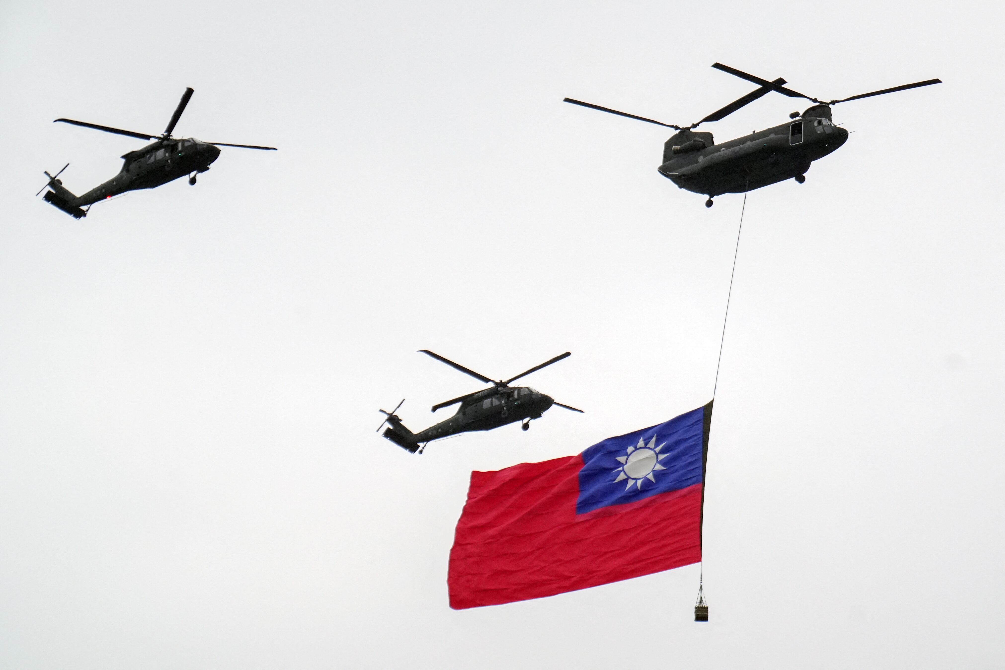 Un helicóptero CH-47 Chinook y un UH-60 Black Hawk del ejército taiwanés vuelan con la bandera de Taiwán en el Día Nacional, Taipéi. Foto: AFP