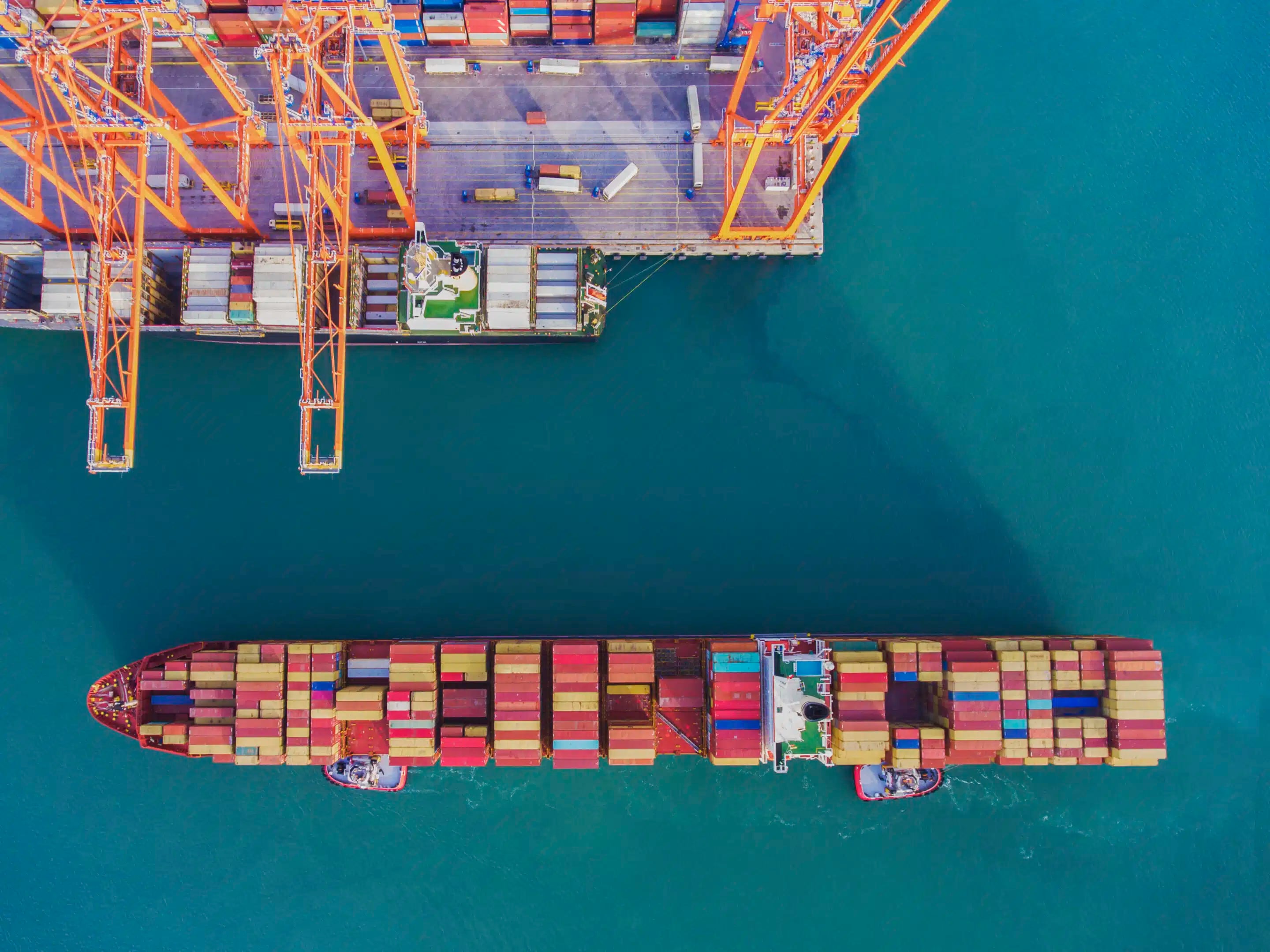 Gran buque de transporte y vista de puerto. Vista aérea de la terminal de contenedores con grúa de carga.