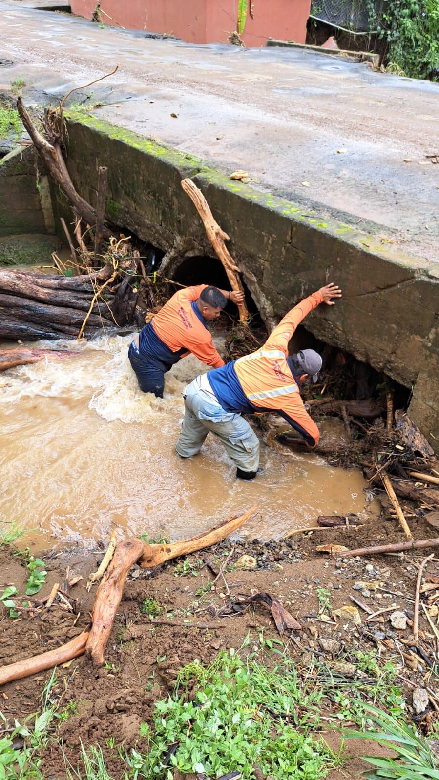 Funcionarios municipales removieron palos y escombros este martes en varios poblados, para facilitar el paso del agua, pues se aproxima una nueva onda. Foto: Cortesía Municipalidad de Garabito.