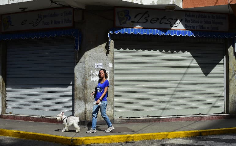 Una mujer pasa frente a una de las tiendas cerradas en Caracas, Venezuela, este vienes. El llamado a huelga de la oposición fue acatado parcialmente.