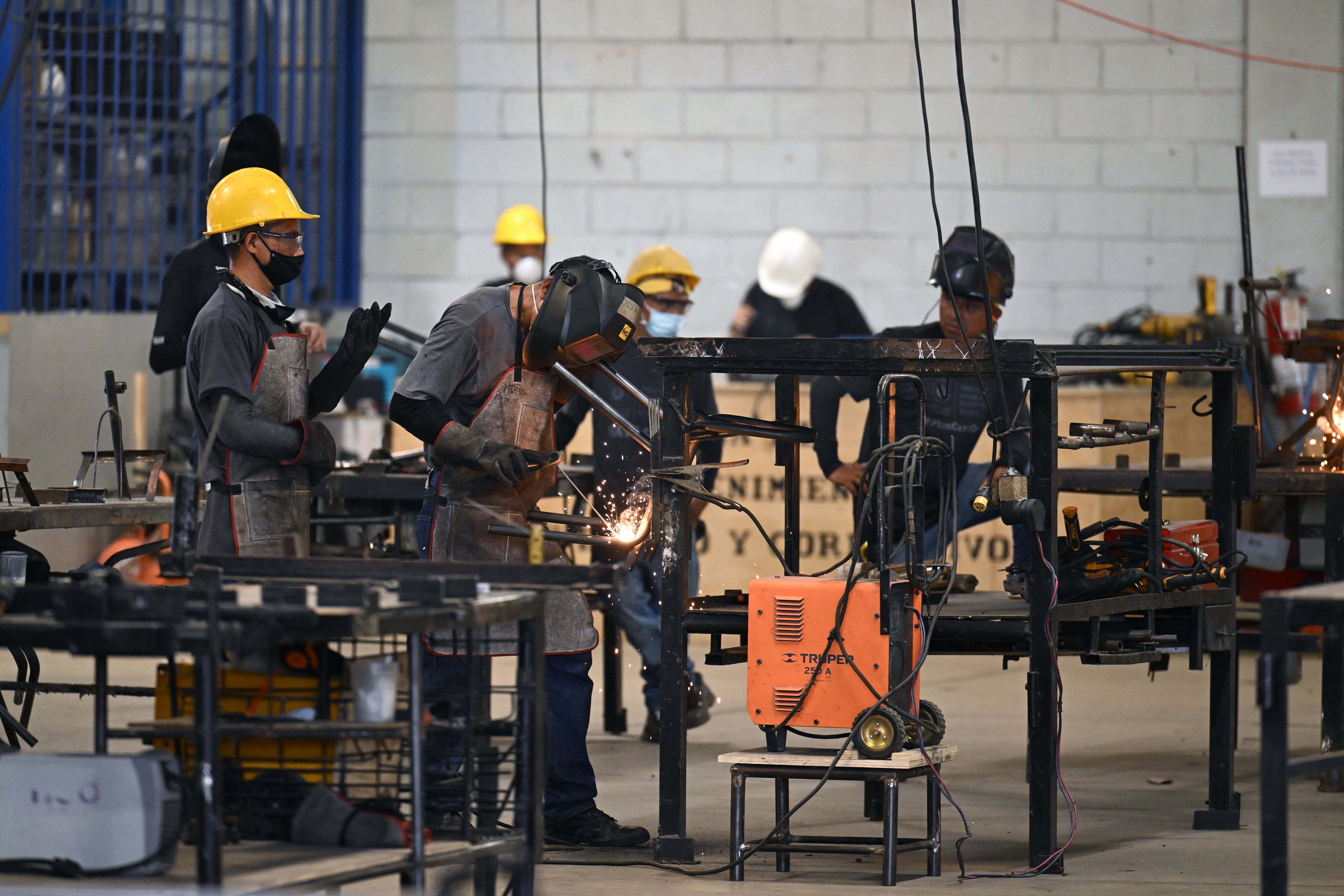 Personas que fueron extorsionadas por pandillas y que ahora están en prisión buscan una segunda oportunidad trabajando en los centros penales, con la esperanza de reintegrarse en la sociedad. Foto: AFP