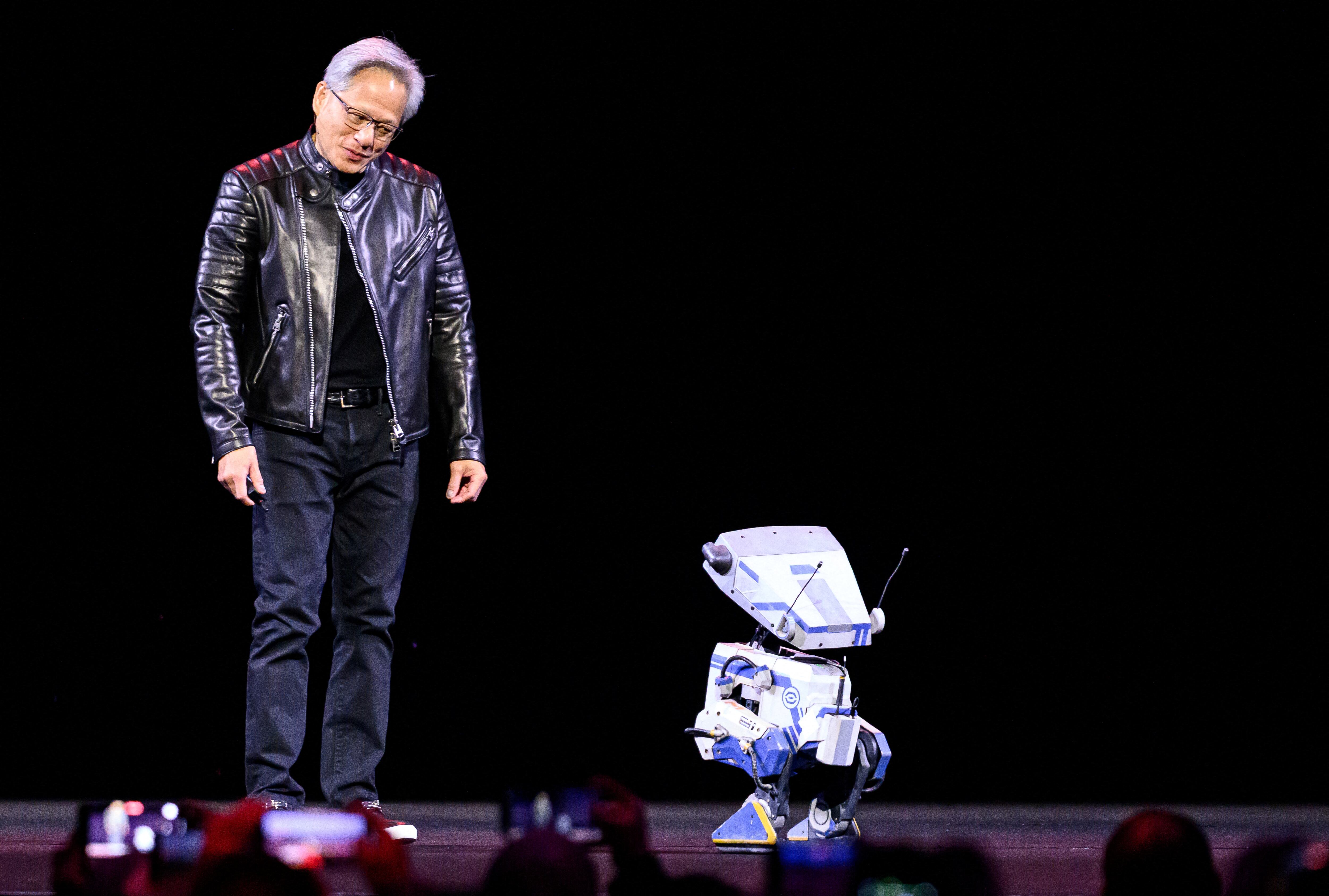 Un hombre asiático conversa con un robot de pequeña estatura