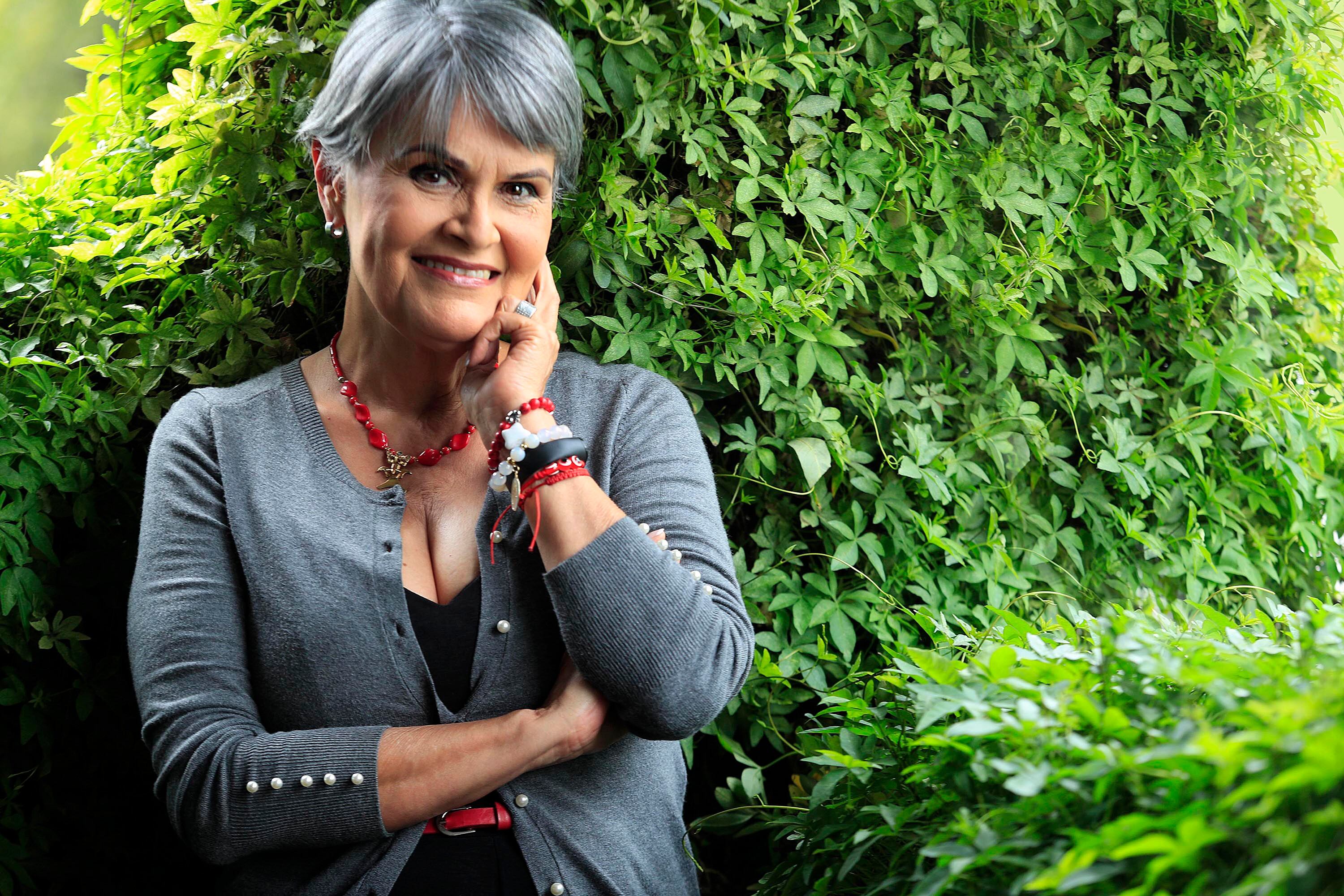 Primer plano de María Torres con arbustos de fondo