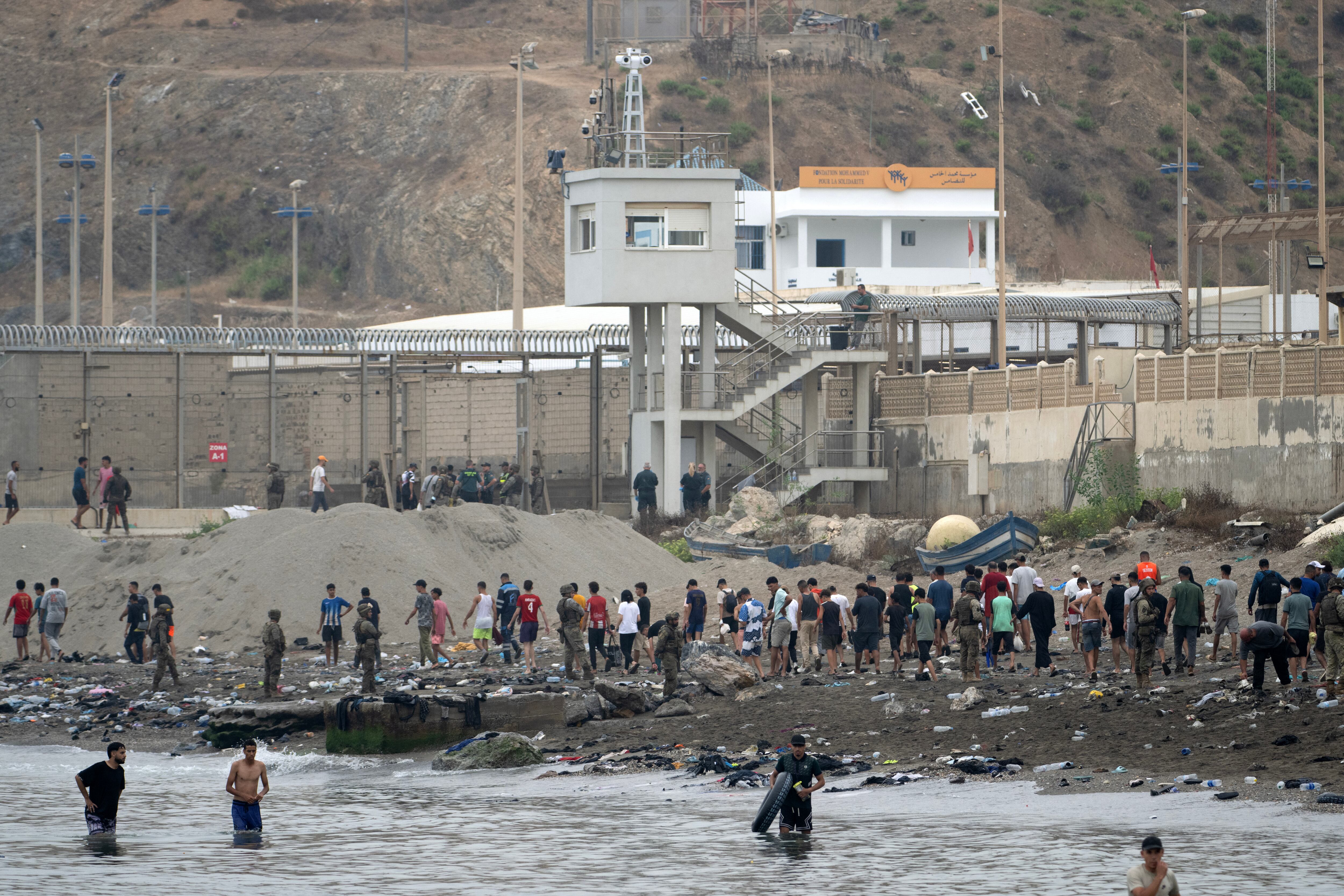 Migrants swim through the waters close to border the with Morocco to enter Spain's north Africa's Ceuta enclave on July 31, 2026. Thousands of migrants crossed overnight from Morocco into Ceuta enclave, a police source said, as Spanish Prime Minister was set to arrive to manage the latest migrant crisis on the border. In recent days, a total of around 40,000 migrants have crossed into the territory, population 80,000, the source added. (Photo by JORGE GUERRERO / AFP)