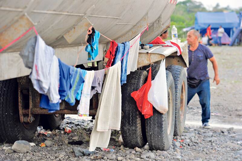 La policía panameña se encarga de la alimentación de los 1.987 cubanos que se mantienen en albergues en ese país. Aquí, en un centro en David, los cubanos hacen largas filas para comer en cualquier recipiente plástico que haga las veces de plato. | ALONSO TENORIO