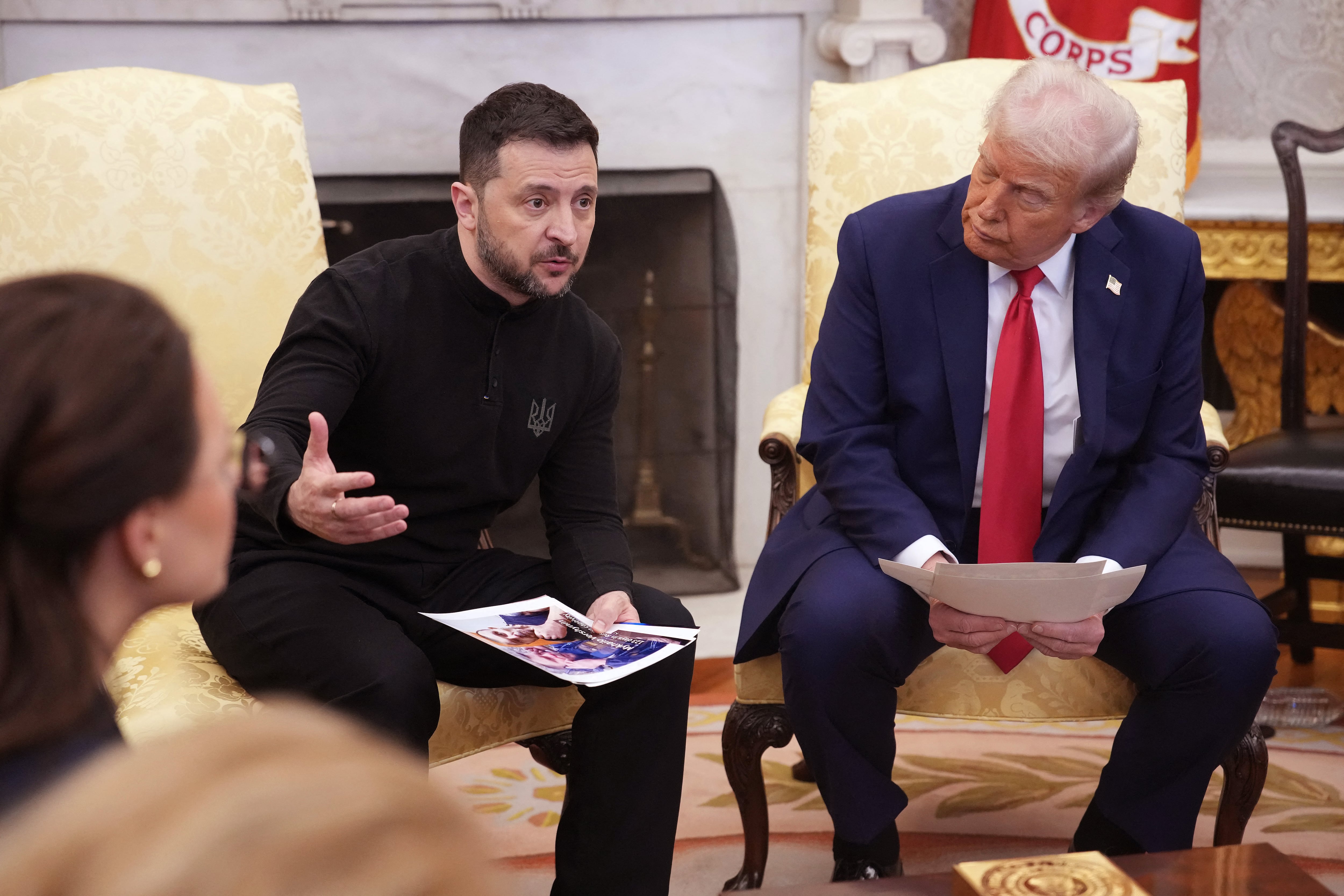 WASHINGTON, DC - FEBRUARY 28: Ukrainian president Volodymyr Zelensky holds photos of Ukrainians who were captures by Russian troops as he meets with U.S. President Donald Trump in the Oval Office at the White House on February 28, 2025 in Washington, DC. Trump and Zelensky are meeting today to sign a preliminary agreement on shar