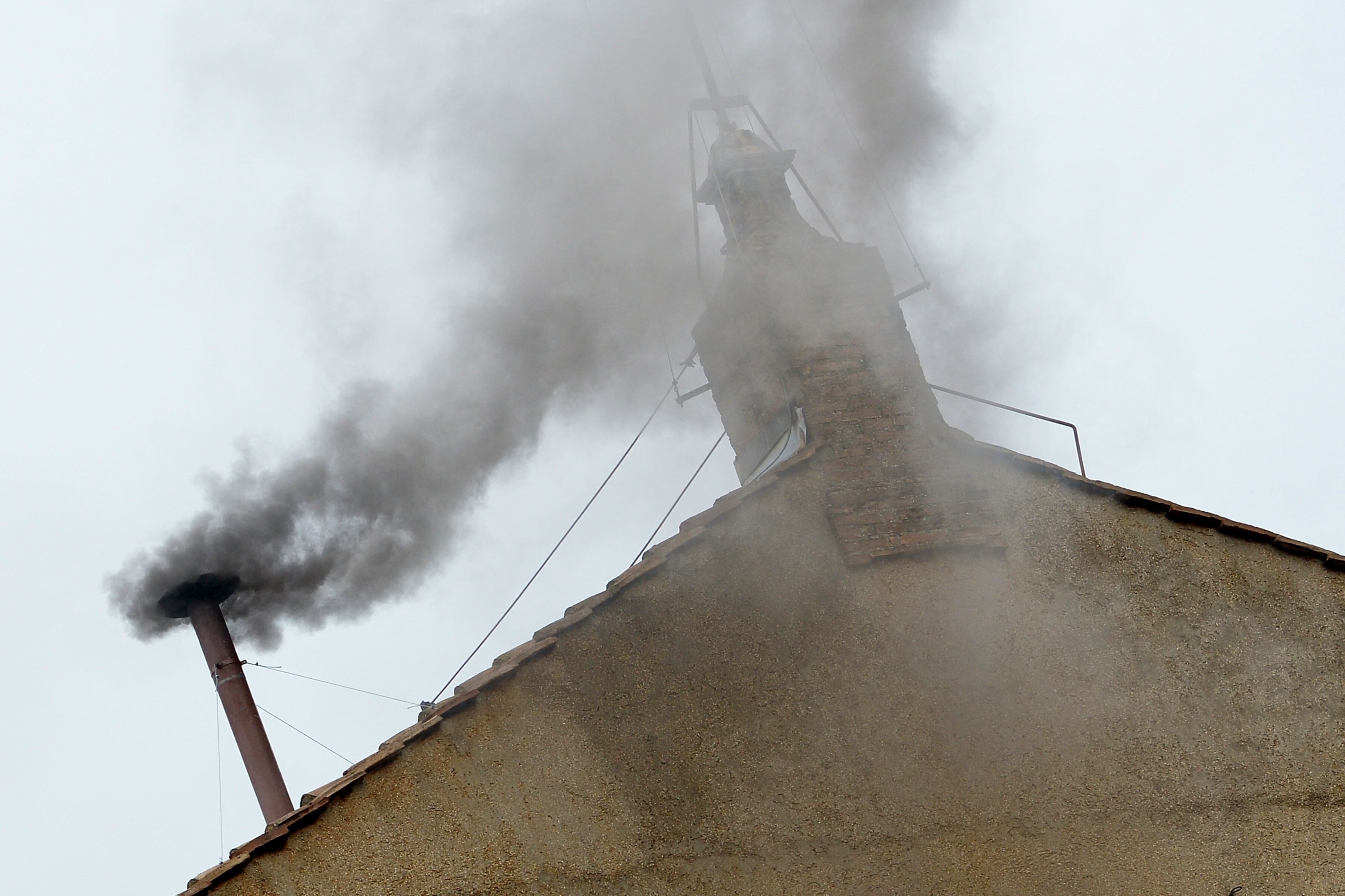 Black smoke rises from the chimney on the roof of the Sistine Chapel meaning that cardinals failed to elect a new pope in the second ballot of their secret conclave on March 13, 2013 at the Vatican. AFP PHOTO / ALBERTO PIZZOLI (Photo by ALBERTO PIZZOLI / AFP)