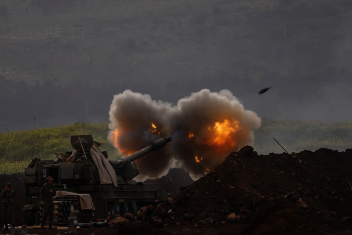An Israeli artillery unit deployed at a position in the upper Galilee in northern Israel near the Lebanon border, fires towards southern Lebanon on March 14, 2026. Lebanon's health ministry said on March 14, that Israeli strikes had killed 26 paramedics and wounded 51 others since conflict erupted between Israel and Hezbollah. Lebanon was drawn into the Middle East war last week when Hezbollah attacked Israel in response to the killing of the Iranian supreme leader in US-Israeli strikes. Israel, which kept up strikes targeting Hezbollah despite a 2024 ceasefire, has since launched attacks across Lebanon and sent ground troops into border areas. (Photo by Jalaa MAREY / AFP) /