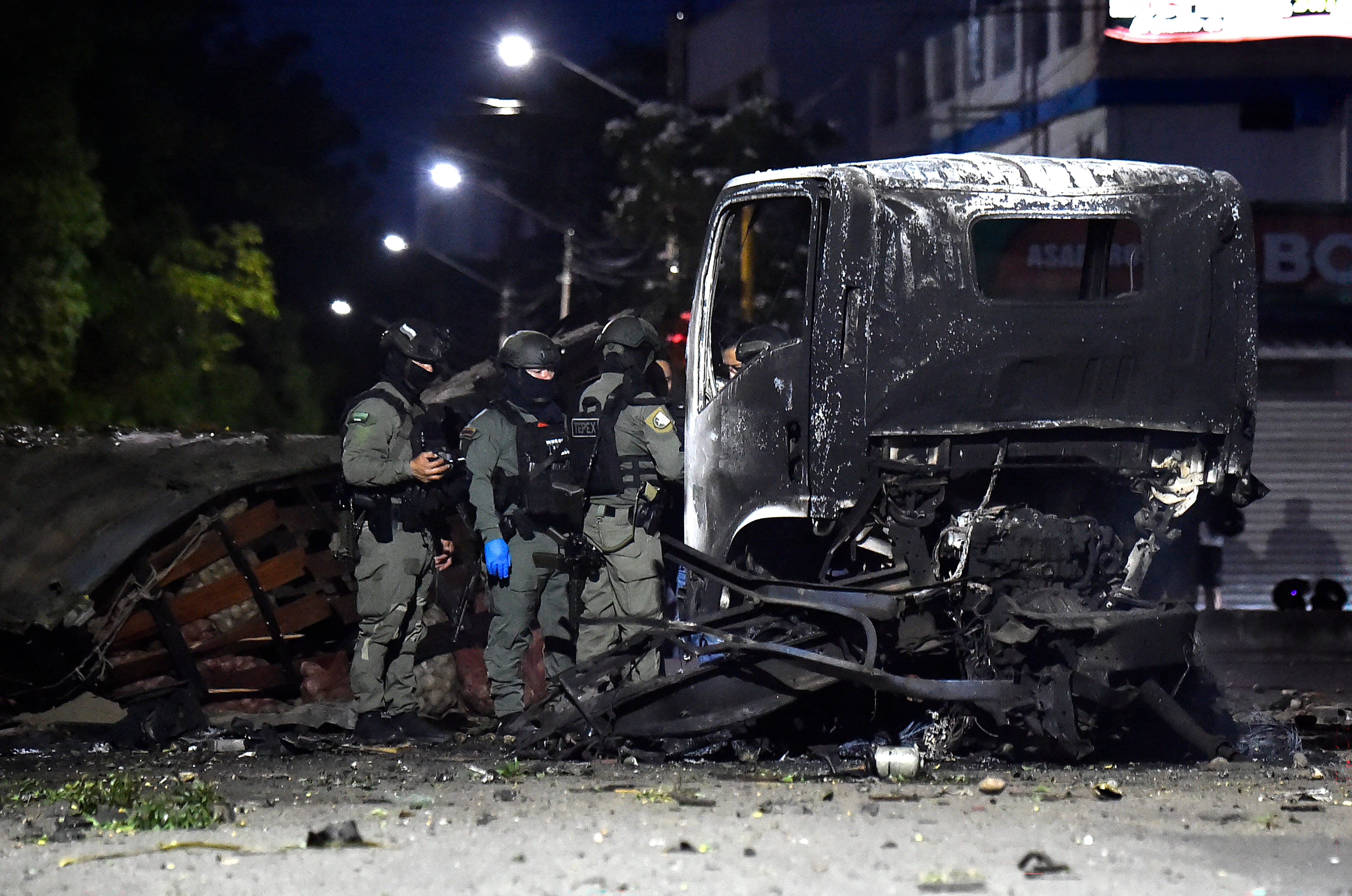 Policías inspeccionan los restos de un camión después de la explosión.