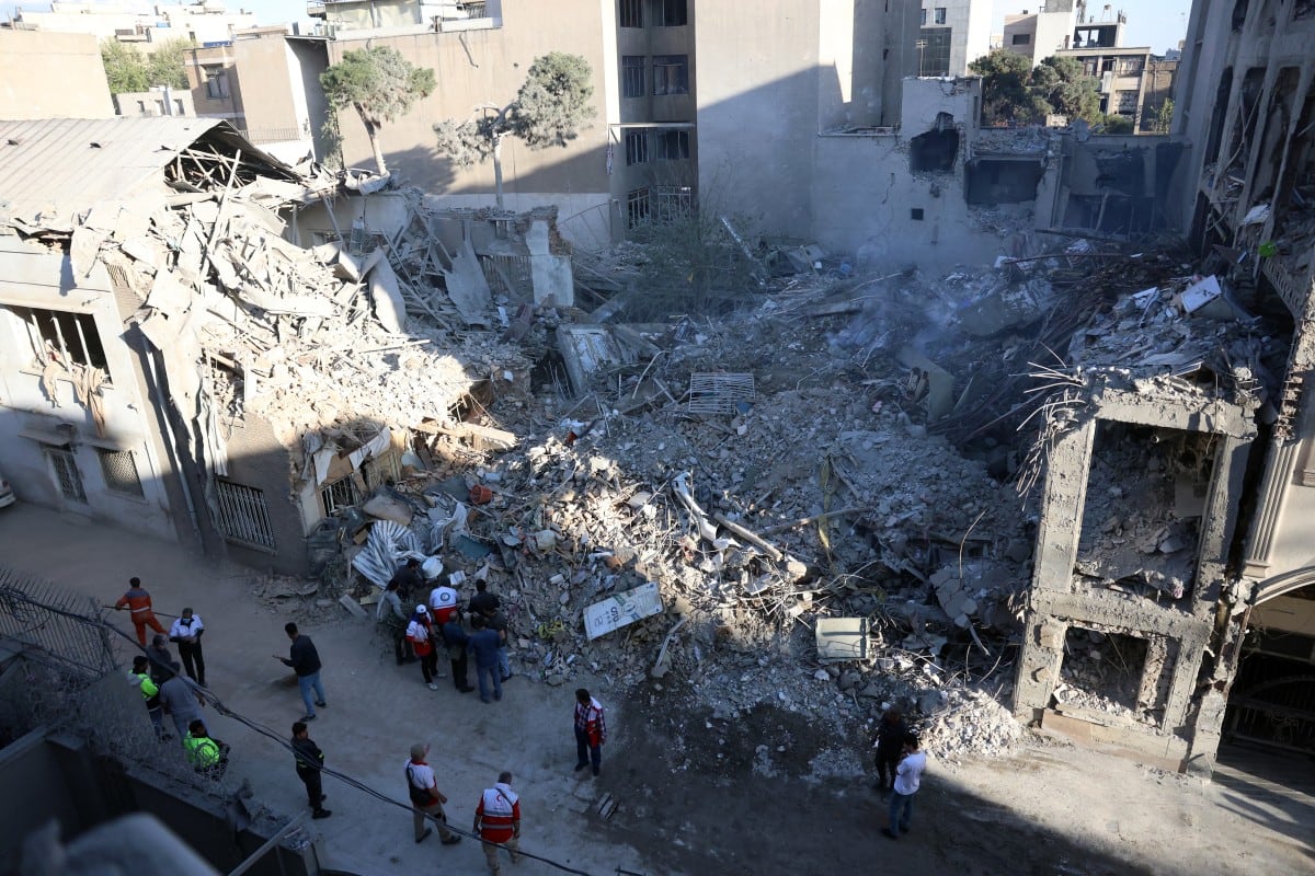 Trabajadores iraníes y voluntarios se reúnen en el lugar de los ataques israelí-estadounidenses que, según medios locales, destruyeron la sinagoga Rafi-Nia y edificios residenciales cercanos en Teherán, el 7 de abril de 2026.