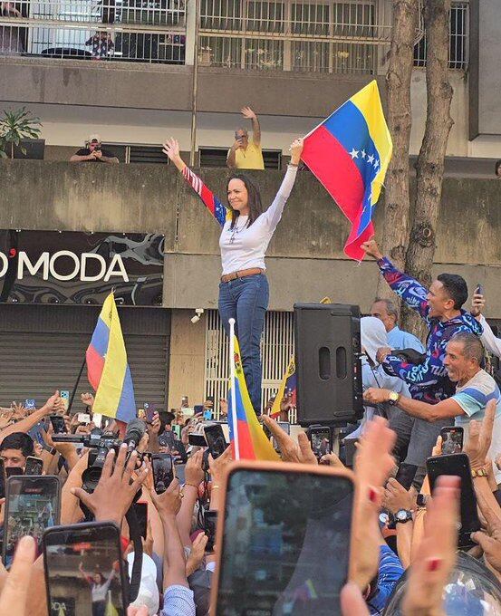 Corina Machado, líder de la oposición venezolana, se dirige a sus seguidores en una manifestación en Caracas, mostrando su compromiso con la lucha democrática