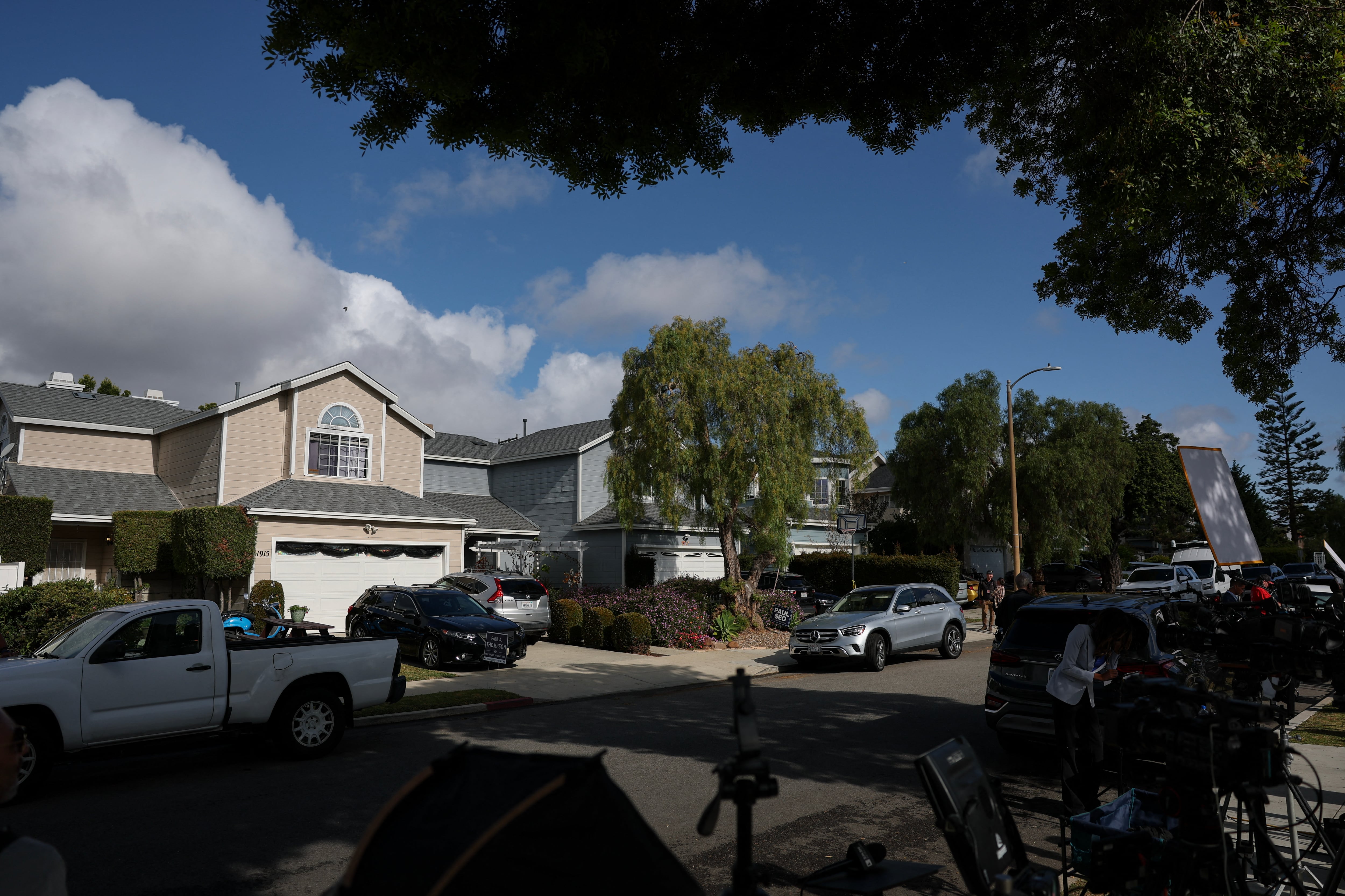 Miembros de la prensa trabajan frente a una vivienda (izquierda) asociada al presunto responsable del tiroteo ocurrido durante la cena de corresponsales de la Casa Blanca, en Torrance, California, el 26 de abril de 2026.
