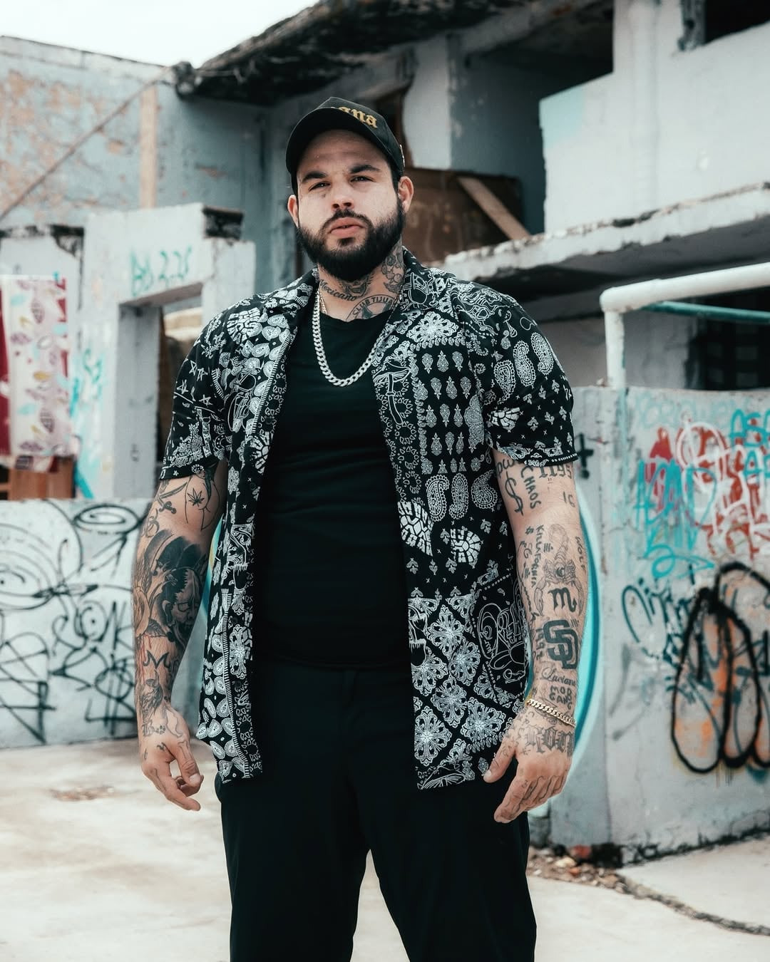 Plano americano de Emiliano Aguilar, hijo de Pepe Aguilar, con paredes graffitteadas de fondo.