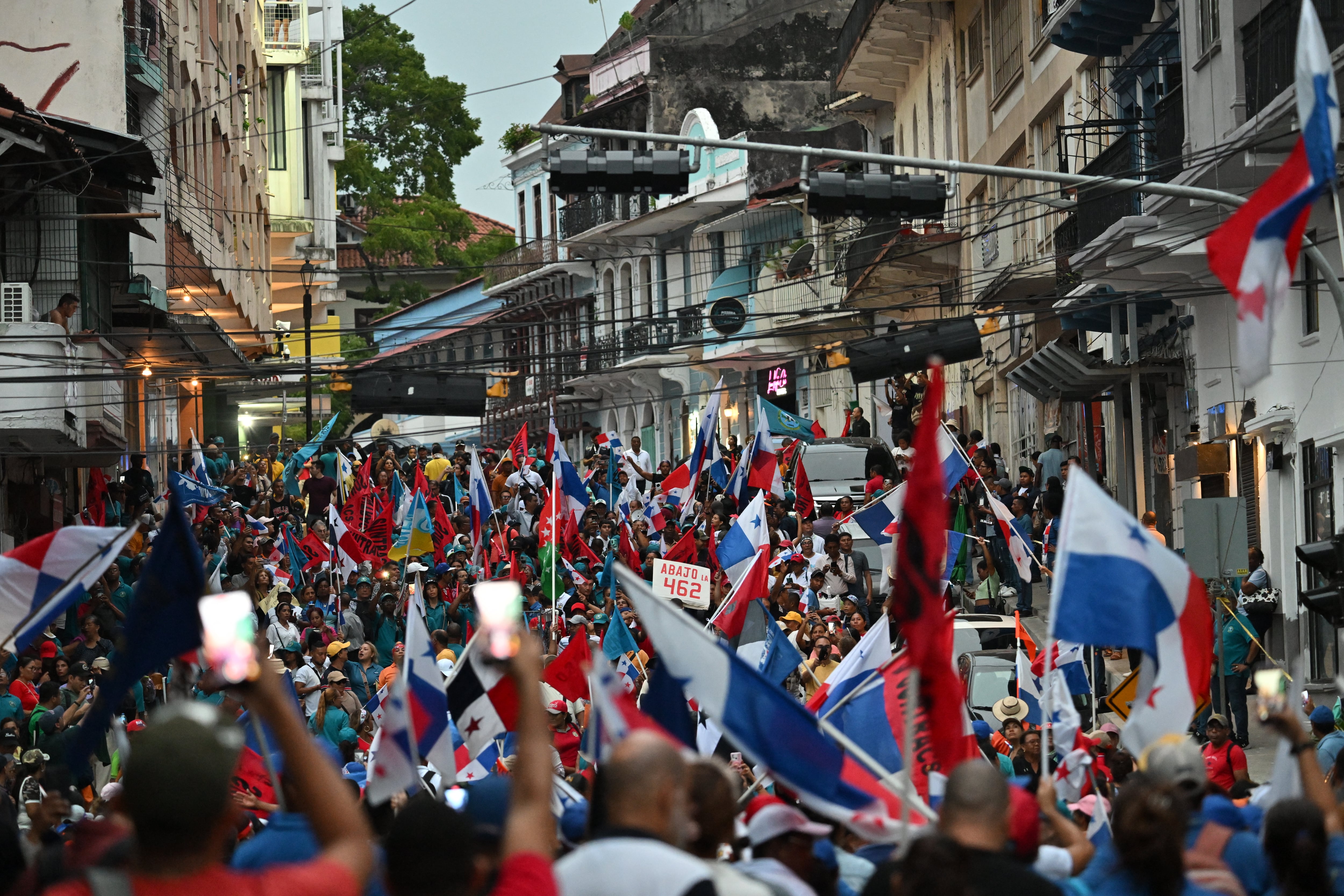 Trabajadores que portan banderas nacionales participan en una protesta contra el gobierno del presidente José Raúl Mulino en medio de una huelga indefinida