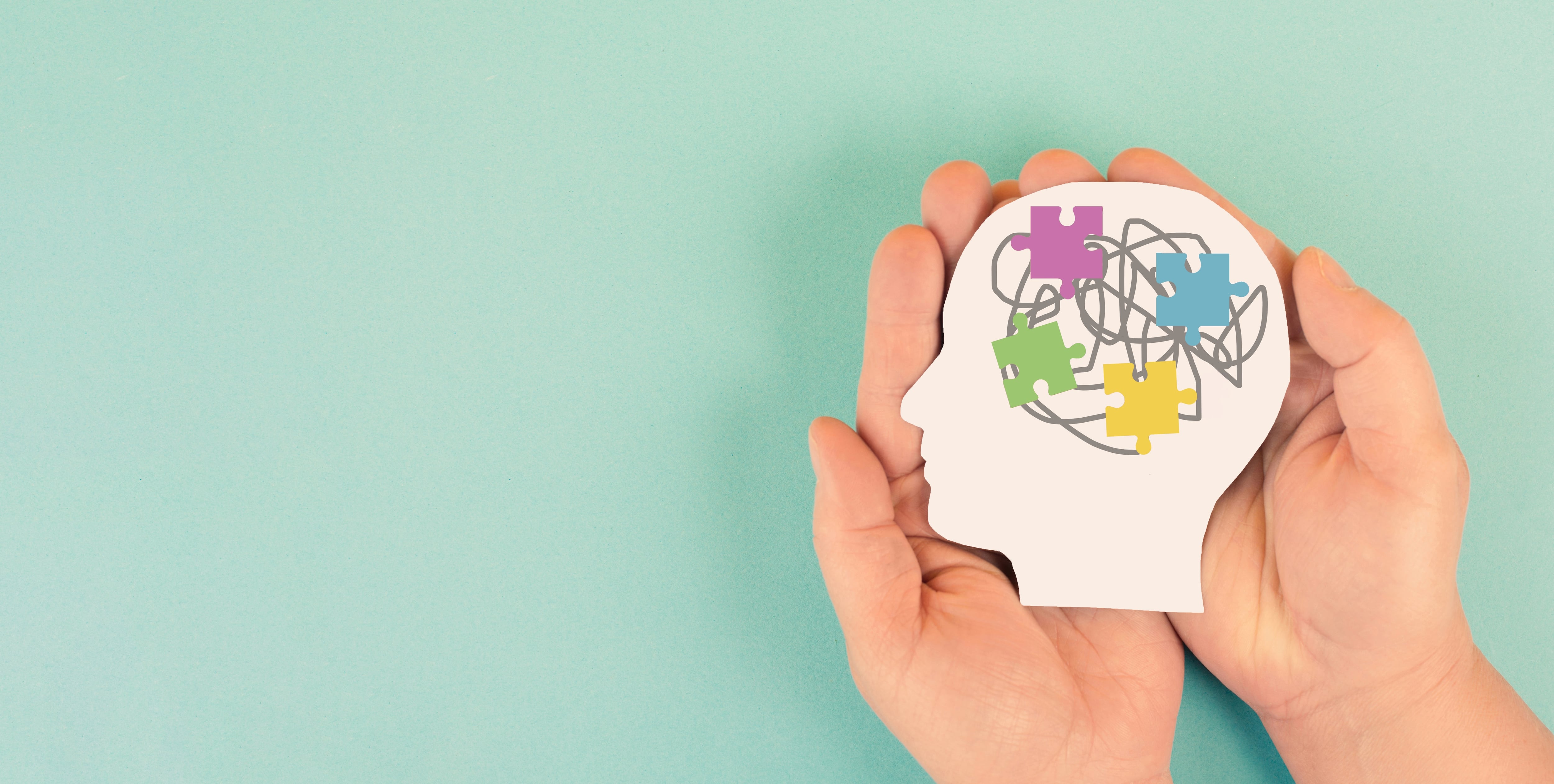 Autismo. Trastorno del espectro autista (TEA), trastorno del neurodesarrollo, déficits en la comunicación e interacción social. Dos manos sostienen dibujo de un cerebro