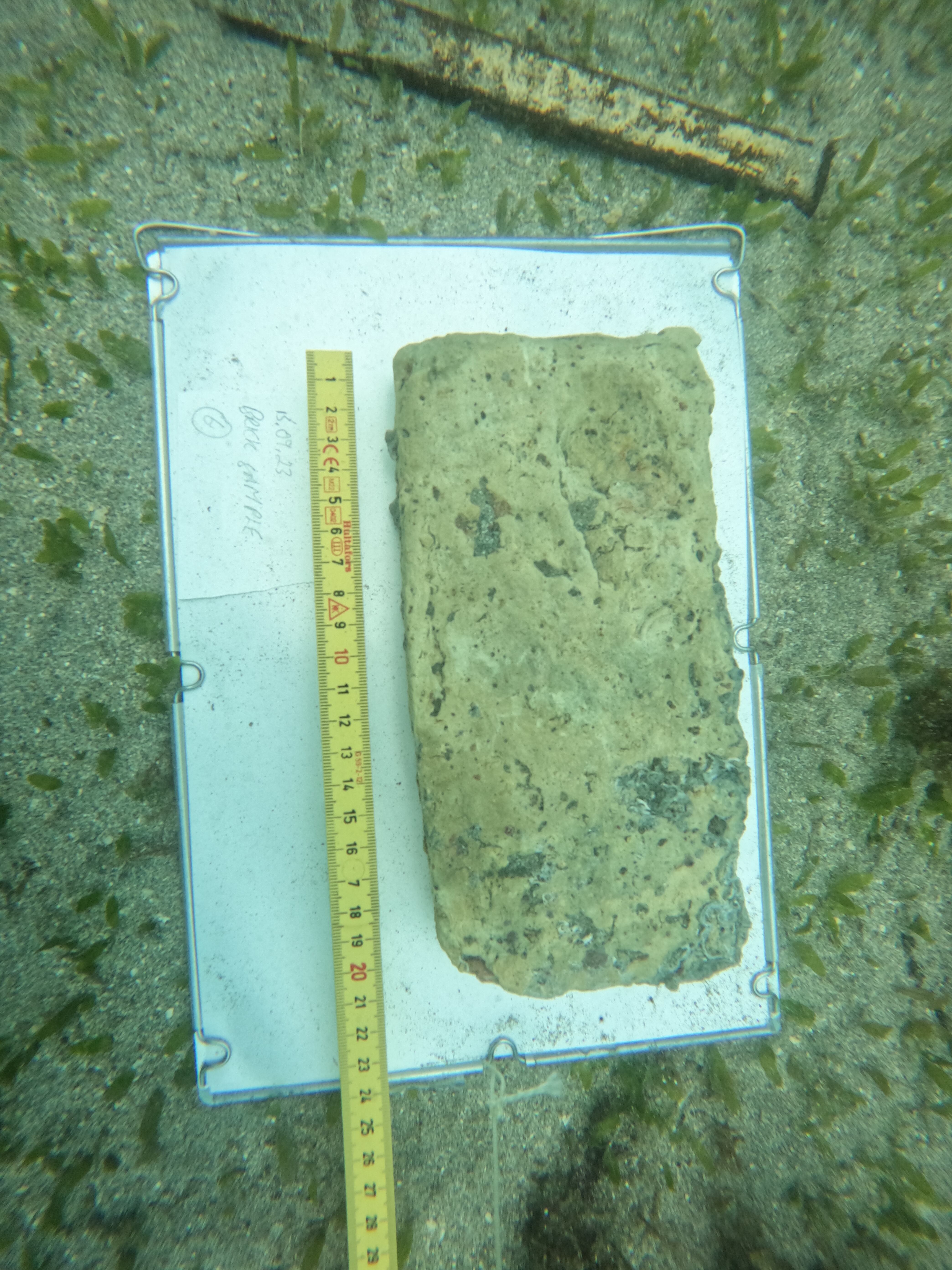 Un ladrillo amarillo de Flensburg es medido y documentado en el lecho marino antes de ser muestreado.