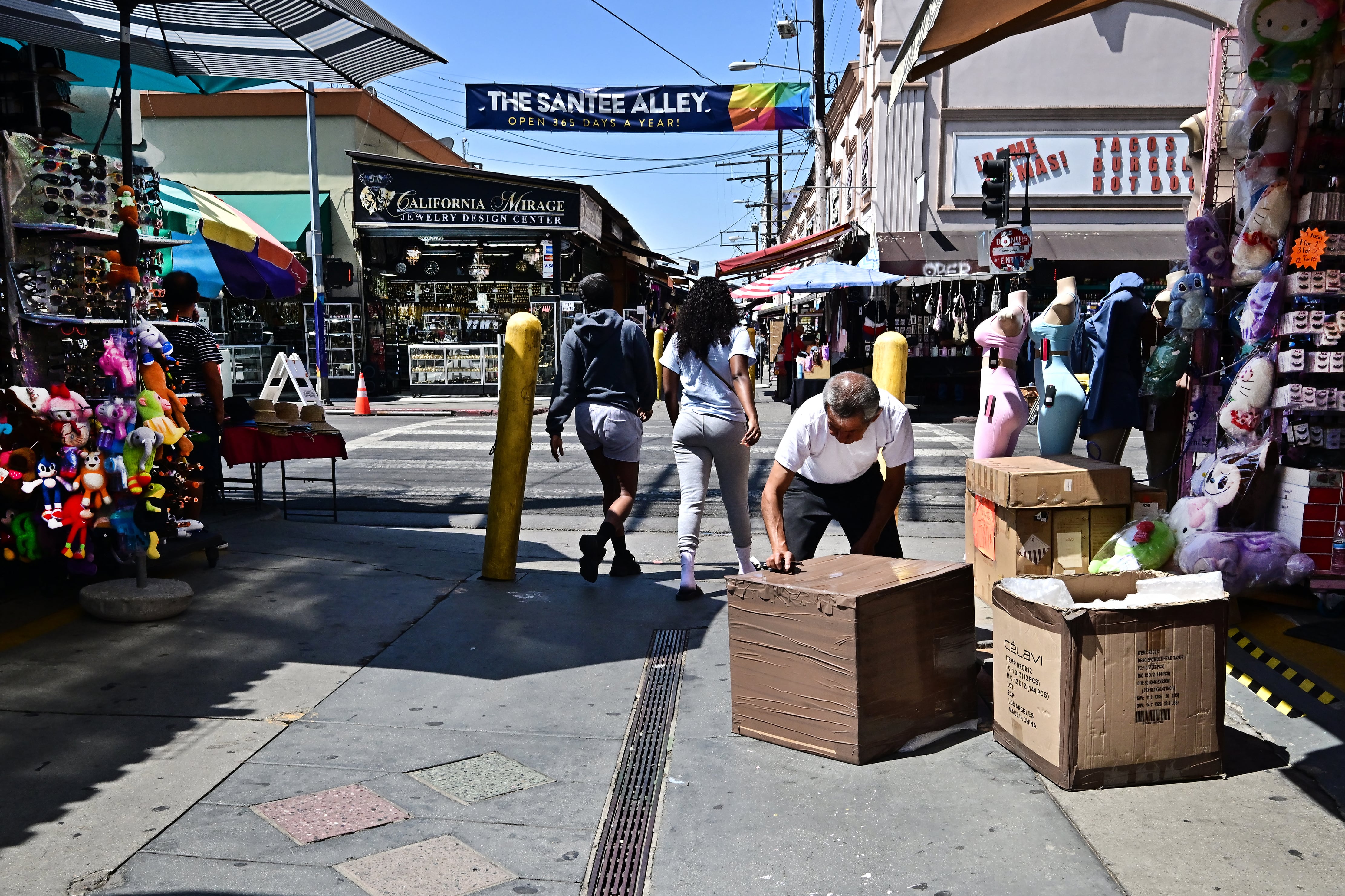 Un comerciante abre cajas frente a un negocio en Santee Alley, en el Fashion District del centro de Los Ángeles, el 3 de julio de 2025. El vecindario, usualmente vibrante y lleno de boutiques y tiendas, se ha convertido en una ciudad fantasma en medio de las redadas de agentes del Servicio de Inmigración y Control de Aduanas de Estados Unidos (ICE), que ejecutan la política de línea dura del presidente Donald Trump de detener y deportar a inmigrantes indocumentados. (Foto de Frederic J. BROWN / AFP)