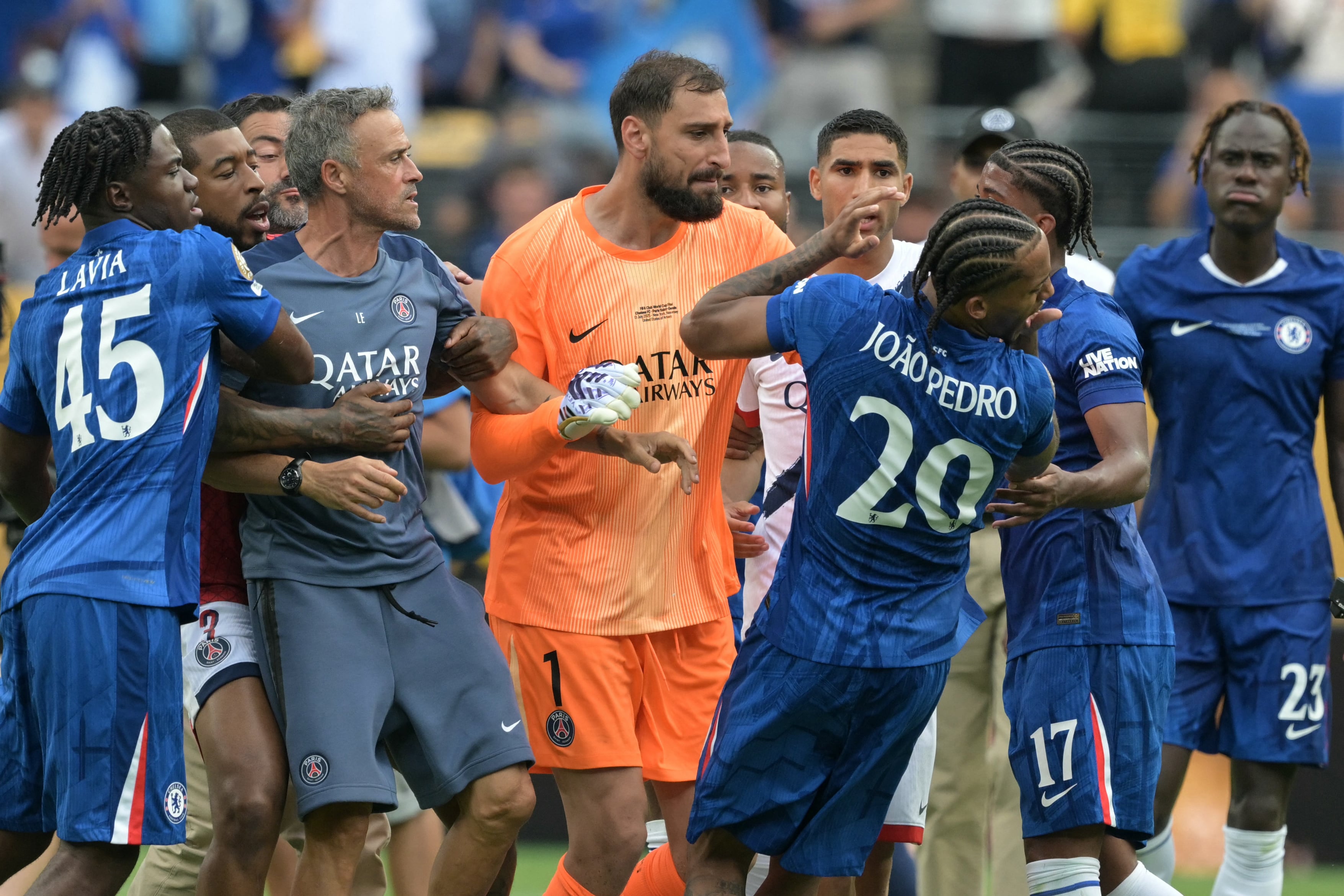 El entrenador español del Paris Saint-Germain, Luis Enrique (izq.), agarra el rostro del delantero brasileño del Chelsea, Joao Pedro, tras perder la final