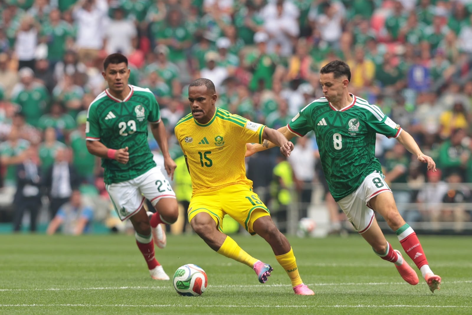 El sudafricano Iqraam Rayners transporta el balón ante los mexicanos Jesús Gallardo (23) y Álvaro Fidalgo, en el Estadio Ciudad de México, durante el partido inaugural del Mundial 2026.