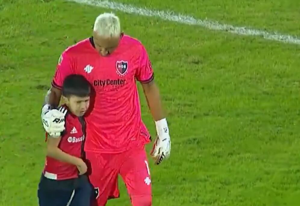 Keylor Navas junto al niño aficionado de Newell's que se metió al campo a saludarlo.