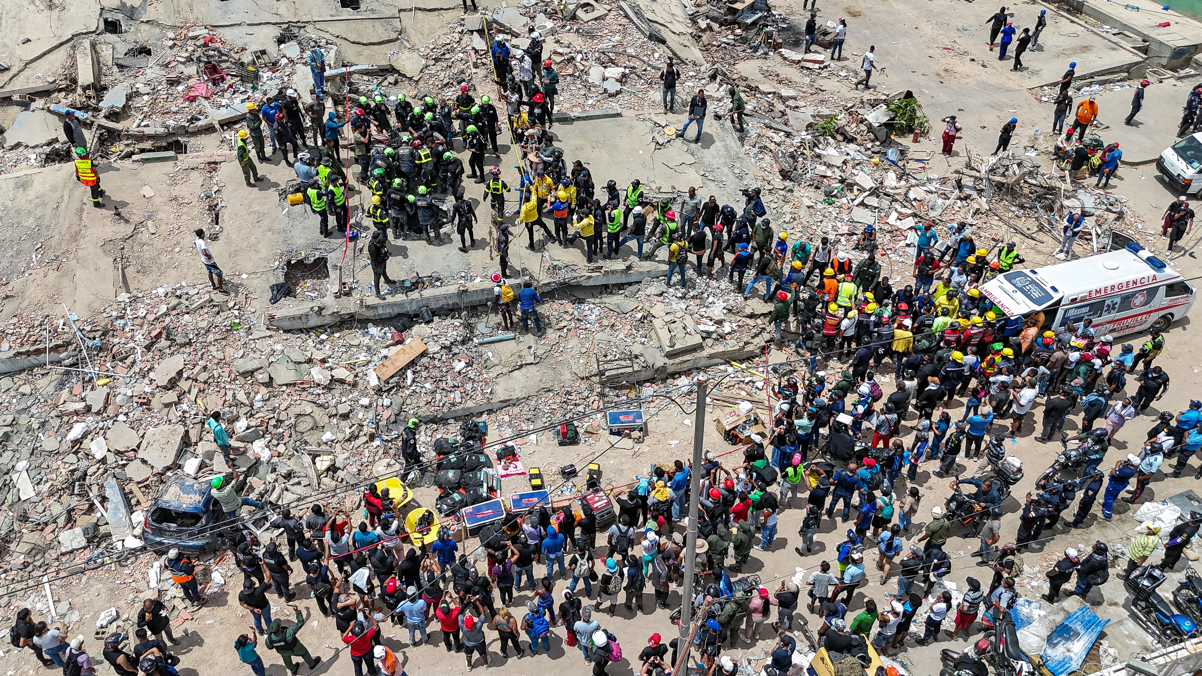 Esta vista aérea muestra a miembros del Regimiento de Instrucción e Intervención de la Seguridad Civil de Francia (UIISC 7) y a rescatistas estadounidenses participando, junto con otro personal de emergencias, en el rescate de una víctima en el sitio de varios edificios colapsados en Caraballeda, estado La Guaira, Venezuela, el 28 de junio de 2026, tras los terremotos.