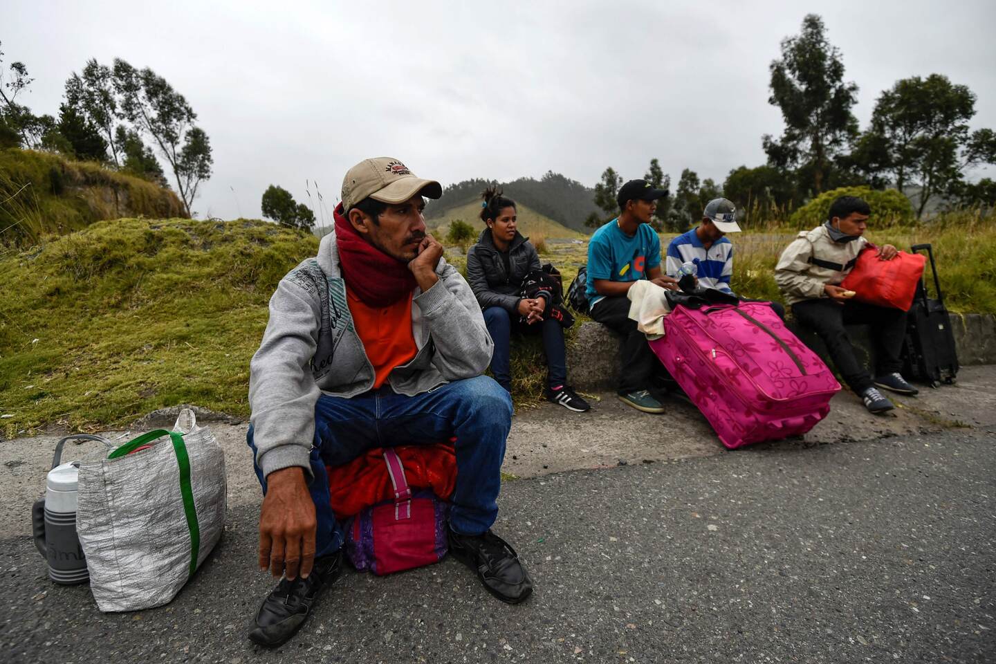Venezuelan migrants rest on their way to Peru at the Panamerican highway in Tulcan, Ecuador, after crossing from Colombia, on August 21, 2018. - Ecuador announced on August 16 that Venezuelans entering the country would need to show passports from August 18 onwards, a document many are not carrying. And Peru followed suit on August 17, announcing an identical measure due to begin on August 25. (Photo by Luis ROBAYO / AFP)