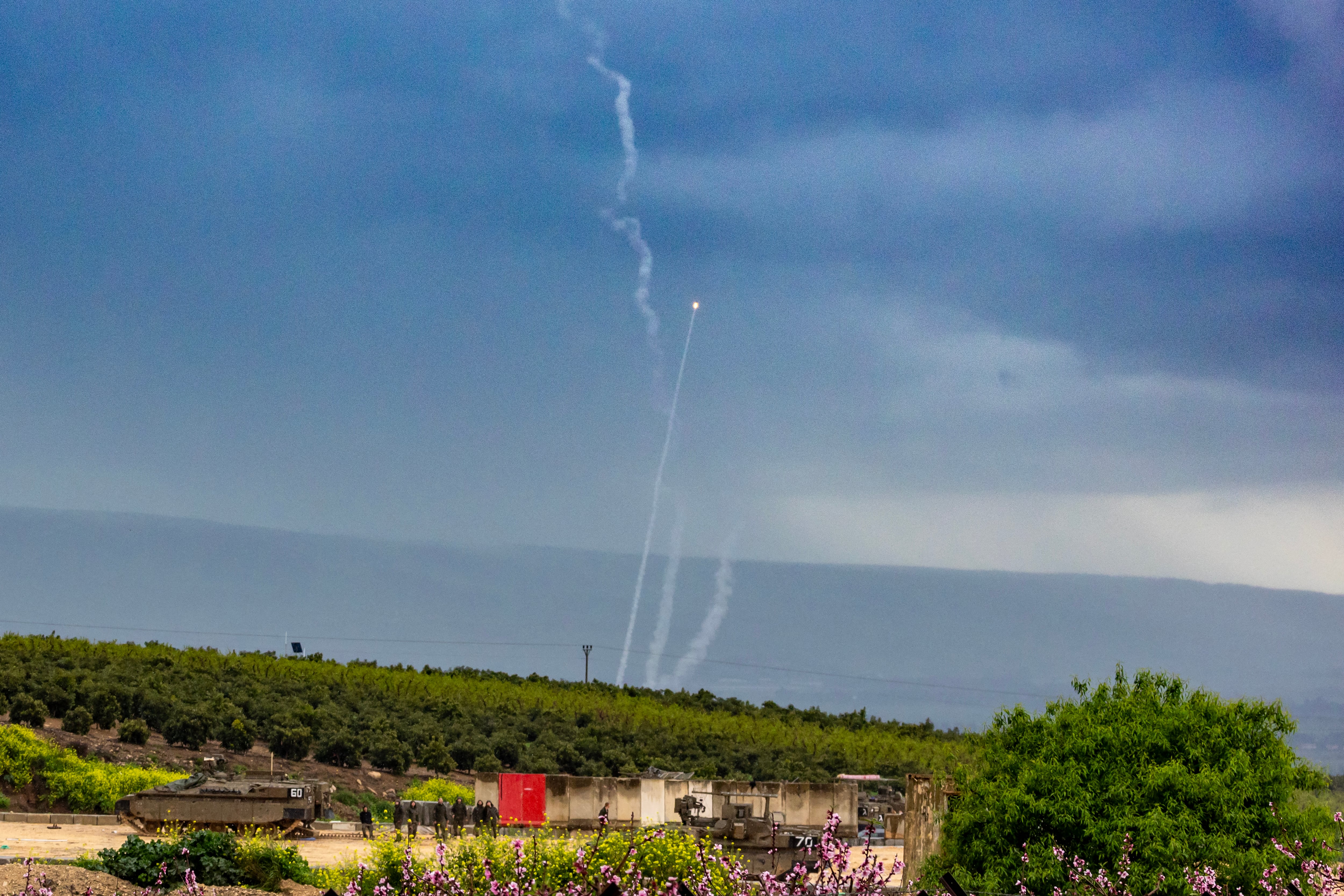 Interceptores del sistema Iron Dome se elevan detrás de un grupo de soldados israelíes a lo largo de la frontera con Líbano, en la Alta Galilea, en el norte de Israel, el 21 de marzo de 2026.