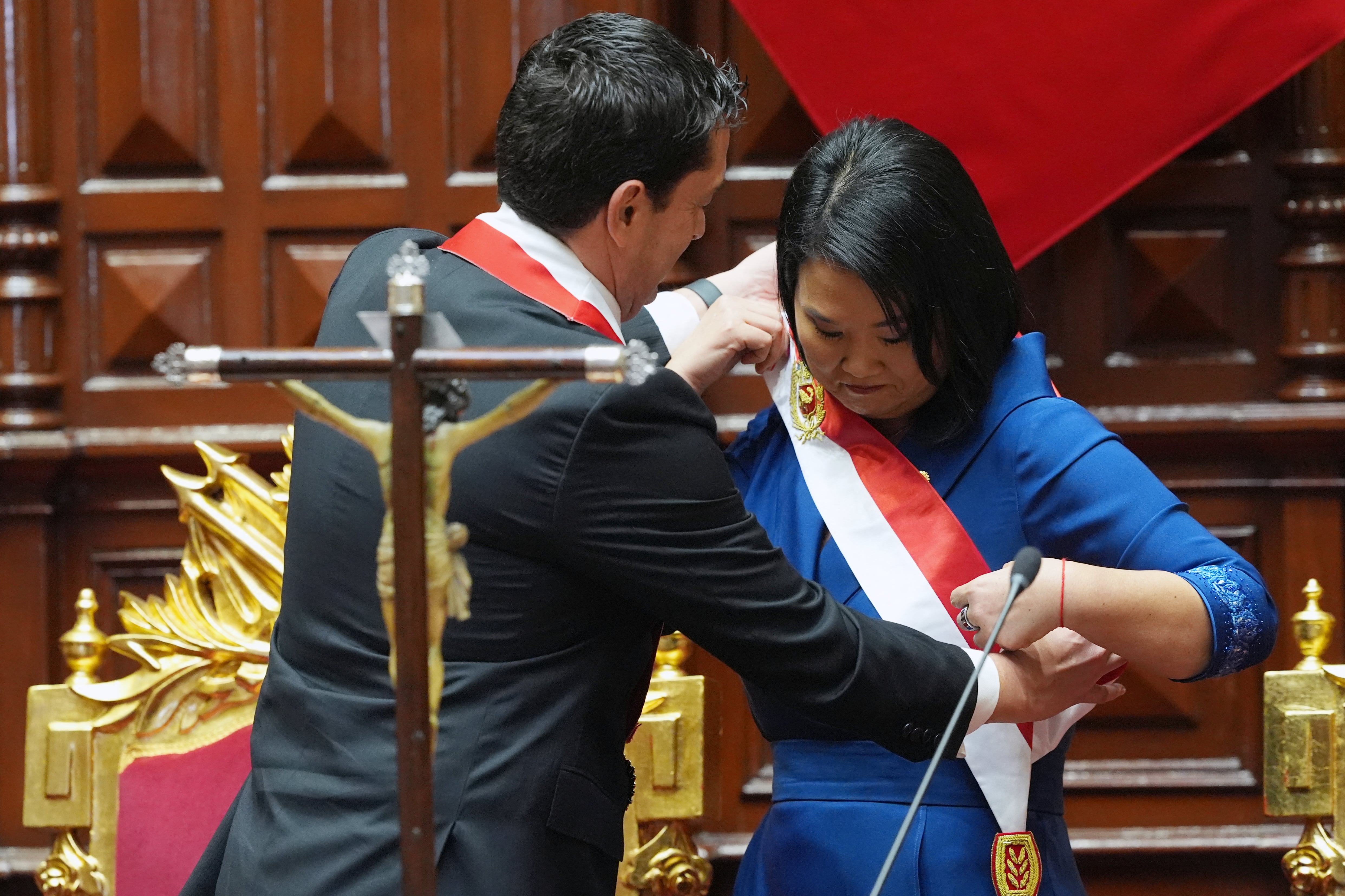 Peru's Congress President Miguel Torres (L) places the presidential sash on President Keiko Fujimori after she took the oath of office in Lima, on July 28, 2026. Peru's right-wing president-elect Keiko Fujimori will take office on July 28, 2026, vowing to tackle the wave of crime sweeping the Andean nation. Fujimori won the June 7 presidential runoff by fewer than 50,000 votes, after losing the past three runoffs. (Photo by Guadalupe Pardo / POOL / AFP)