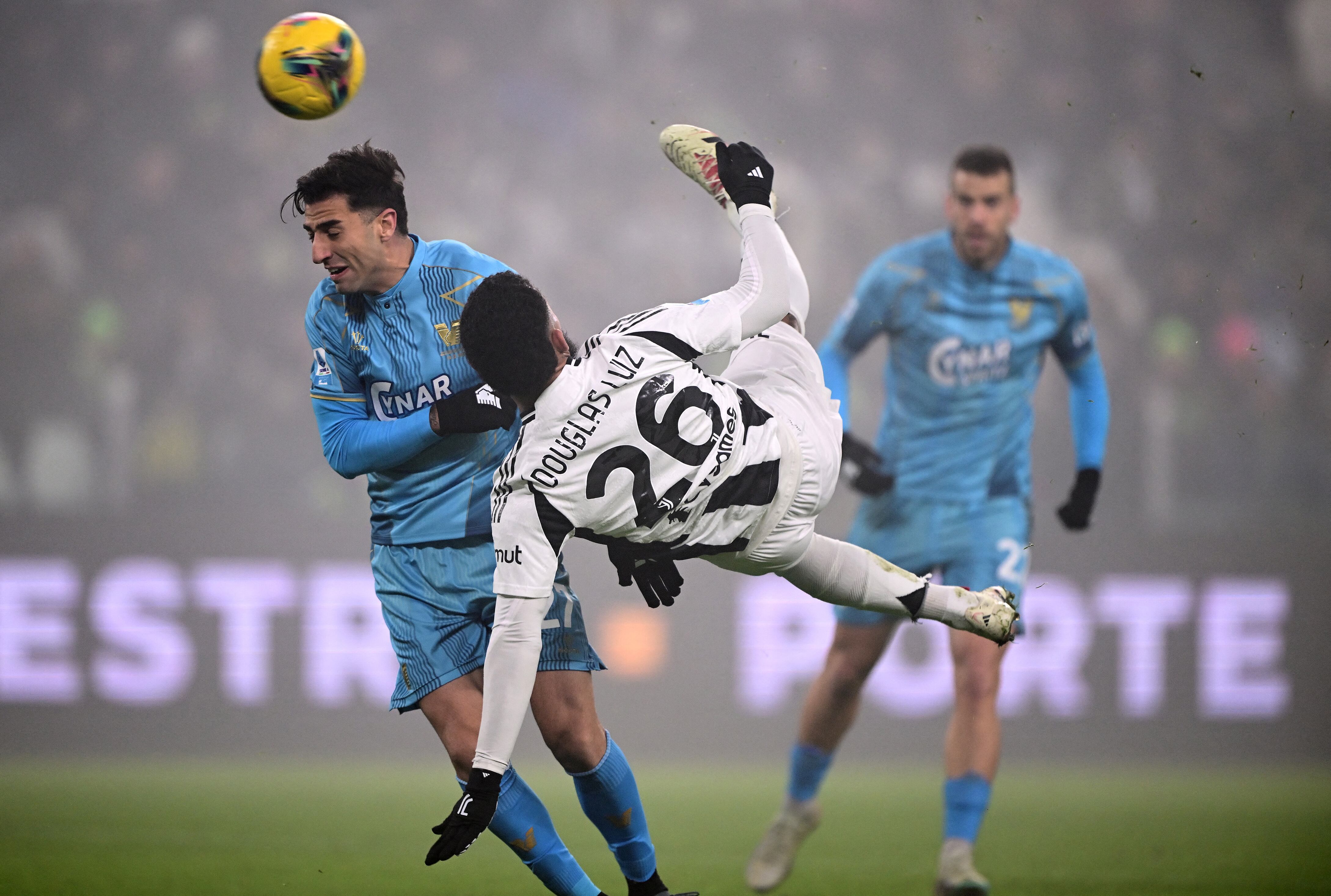 Juventus' Brazilian midfielder #26 Douglas Luiz (C) attempts a bicycle kick during the Italian Serie A football match between Juventus FC and Venezia FC at the Allianz Stadium in Turin, on December 14, 2024. (Photo by MARCO BERTORELLO / AFP)