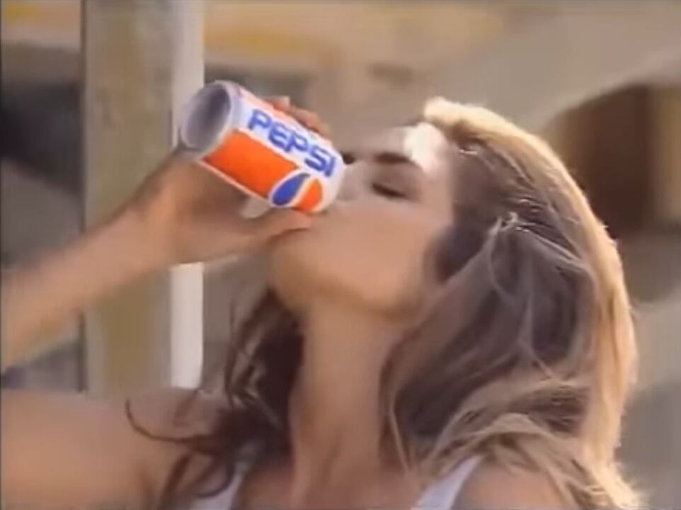 Primer plano de Cindy Crawford tomando una lata de Pepsi