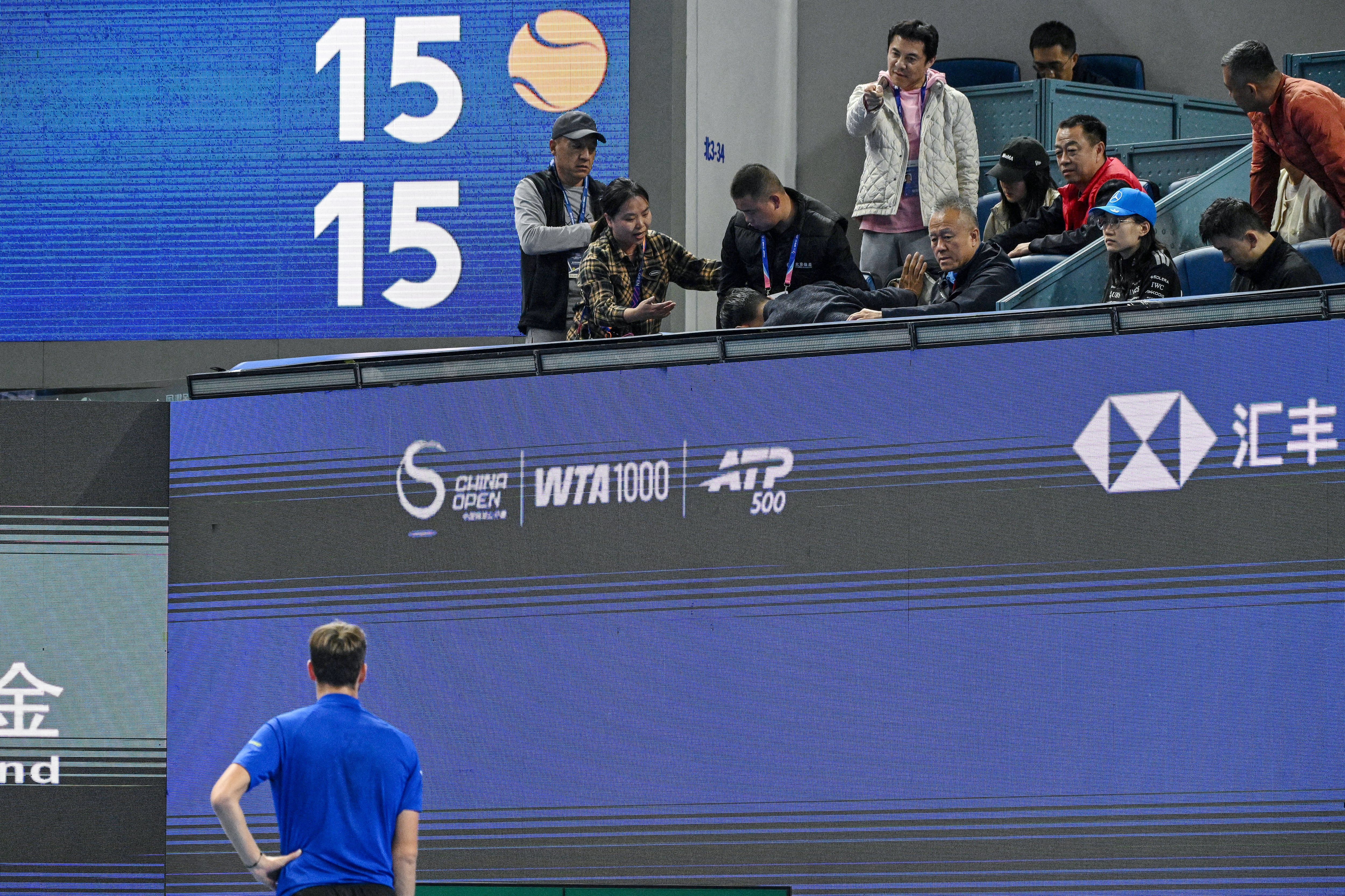 Un espectador señala al tenista Daniil Medvedev, mientras otro aficionado es atendido en el torneo de Pekín tras el pelotazo.