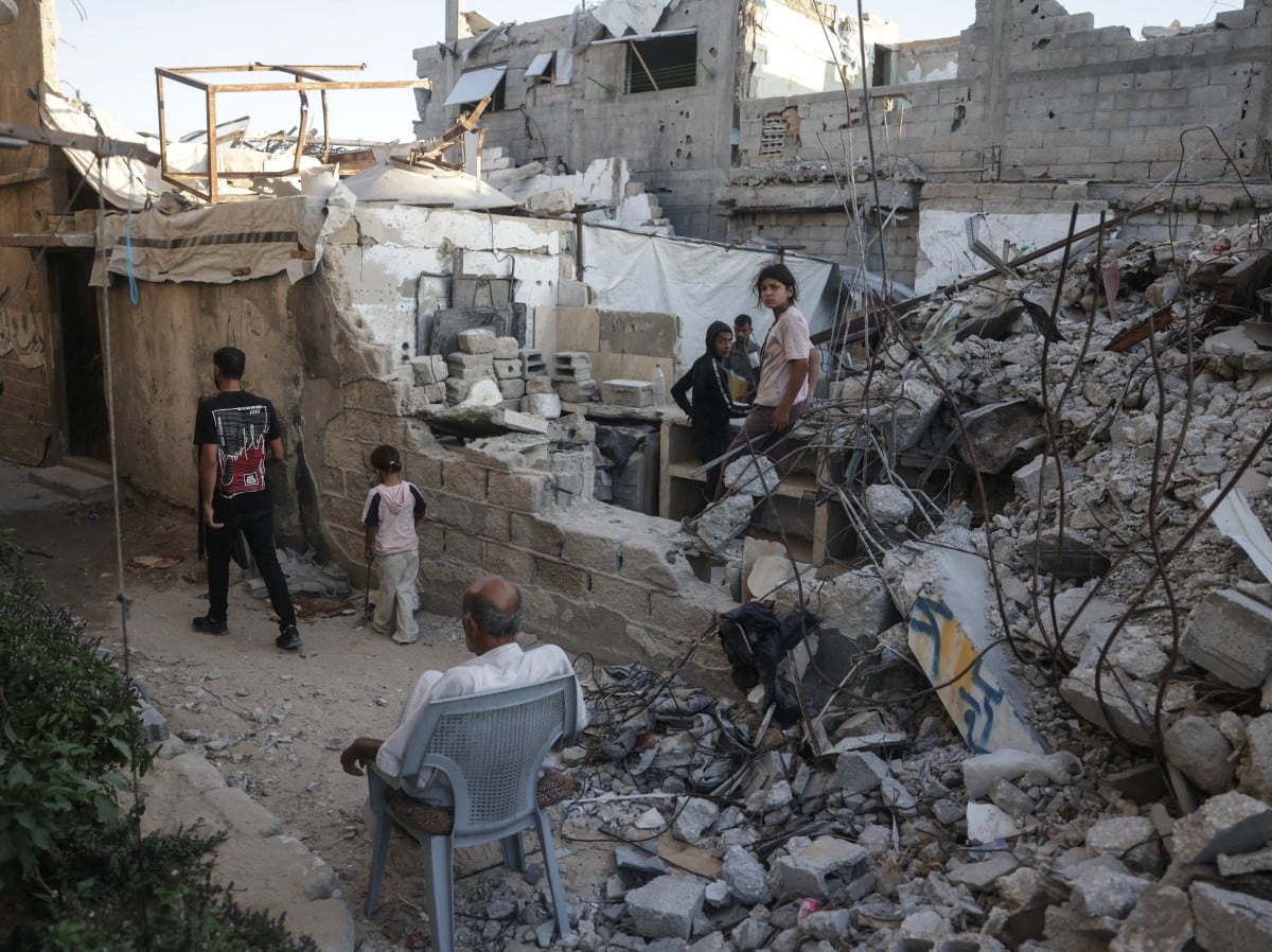 Palestinos desplazados se reúnen entre los escombros de un edificio gravemente dañado que era utilizado como refugio, en Jan Yunis, en el sur de la Franja de Gaza, el 19 de septiembre de 2026.