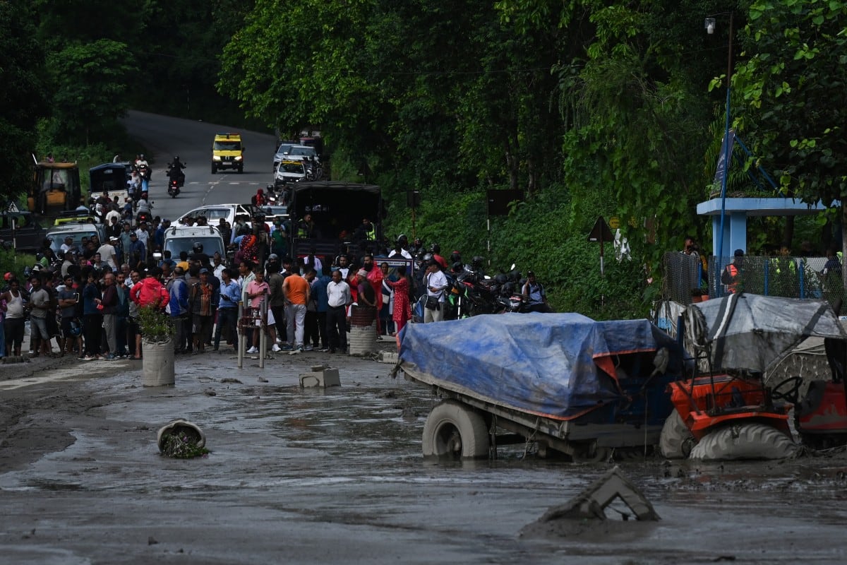 Residentes observan edificios y una calle cubiertos de lodo tras las inundaciones repentinas y un deslizamiento de tierra en Devighat, en el distrito de Nuwakot, Nepal, el 26 de agosto de 2026.